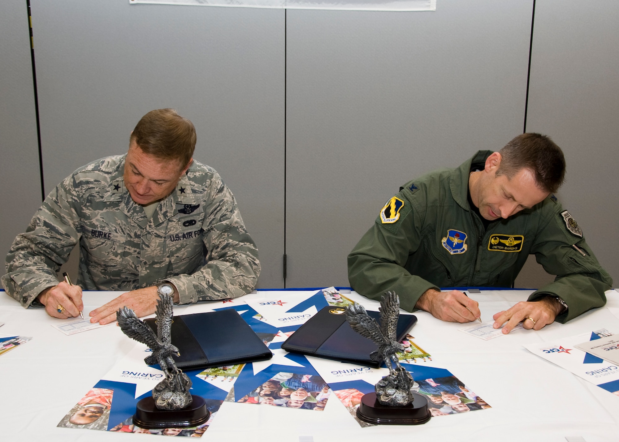 Brig. Gen. Darryl Burke, 82nd Training Wing Commander, and Col. Dieter Bareihs, 80th Flying Training Wing Commander, sign pledge cards at the Combined Federal Campaign Breakfast Kickoff Sept. 1, 2011 at Sheppard Air Force Base, Texas.