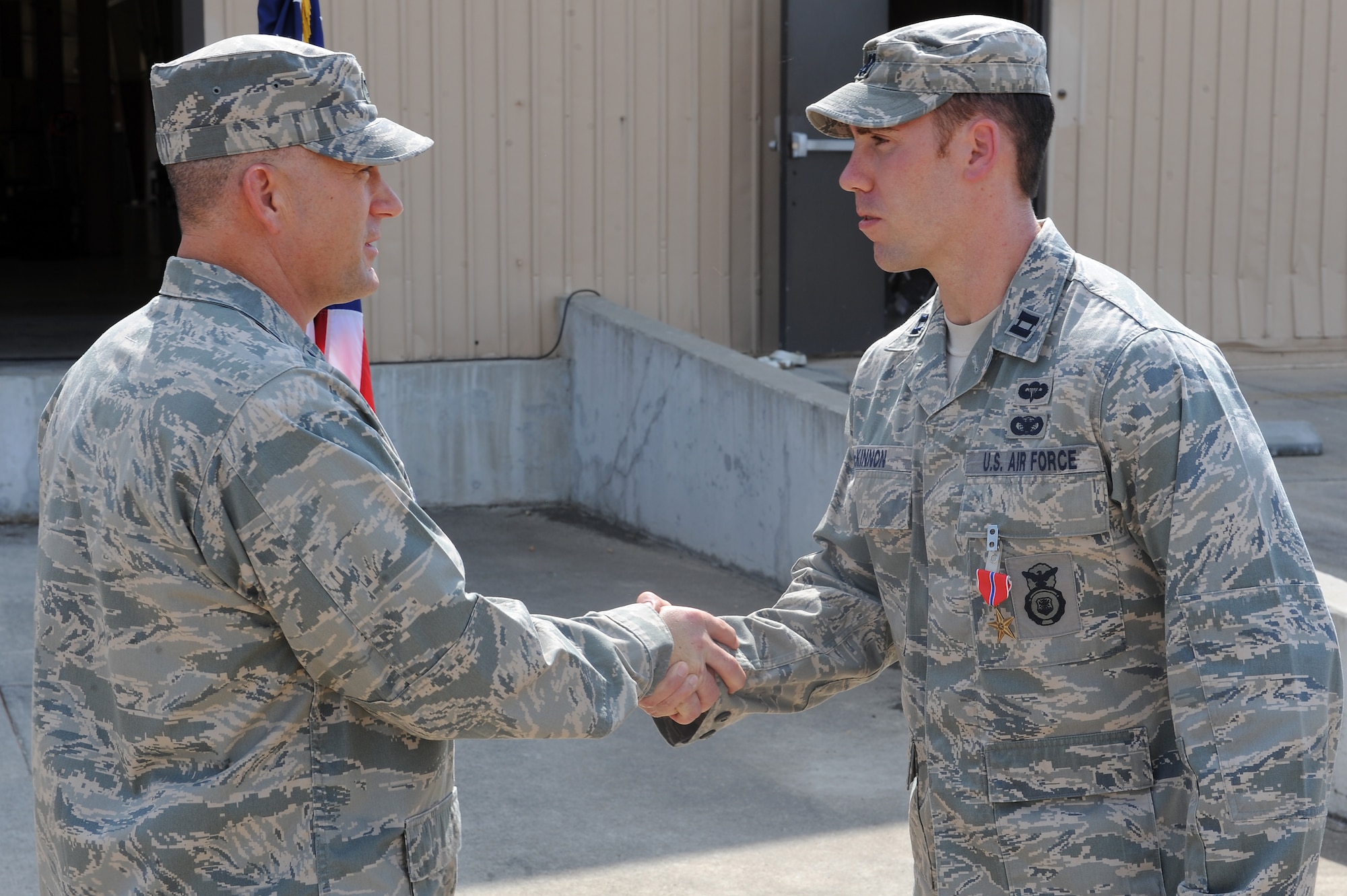 U.S. Air Force Col. Randall Richert, 820th Base Defense Group commander, left, shakes the hand of Capt. Brandon McKinnon, 824th Base Defense Squadron, after presenting him with a Bronze Star Medal at Moody Air Force Base, Ga., Sept. 1, 2011. McKinnon  earned the award for his leadership skills while deployed as the operations officer to Balad, Iraq.  
 (U.S. Air Force photo by Senior Airman Ciara Wymbs/Released) 
