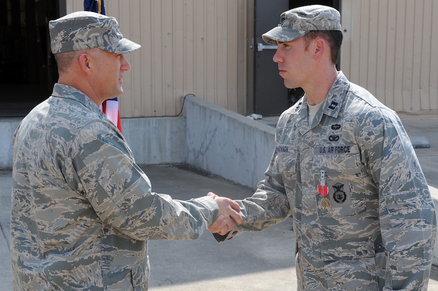 U.S. Air Force Col. Randall Richert, 820th Base Defense Group commander, left, shakes the hand of Capt. Brandon McKinnon, 824th Base Defense Squadron, after presenting him with a Bronze Star Medal at Moody Air Force Base, Ga., Sept. 1, 2011. McKinnon  earned the award for his leadership skills while deployed as the operations officer to Balad, Iraq.  
 (U.S. Air Force photo by Senior Airman Ciara Wymbs/Released) 
