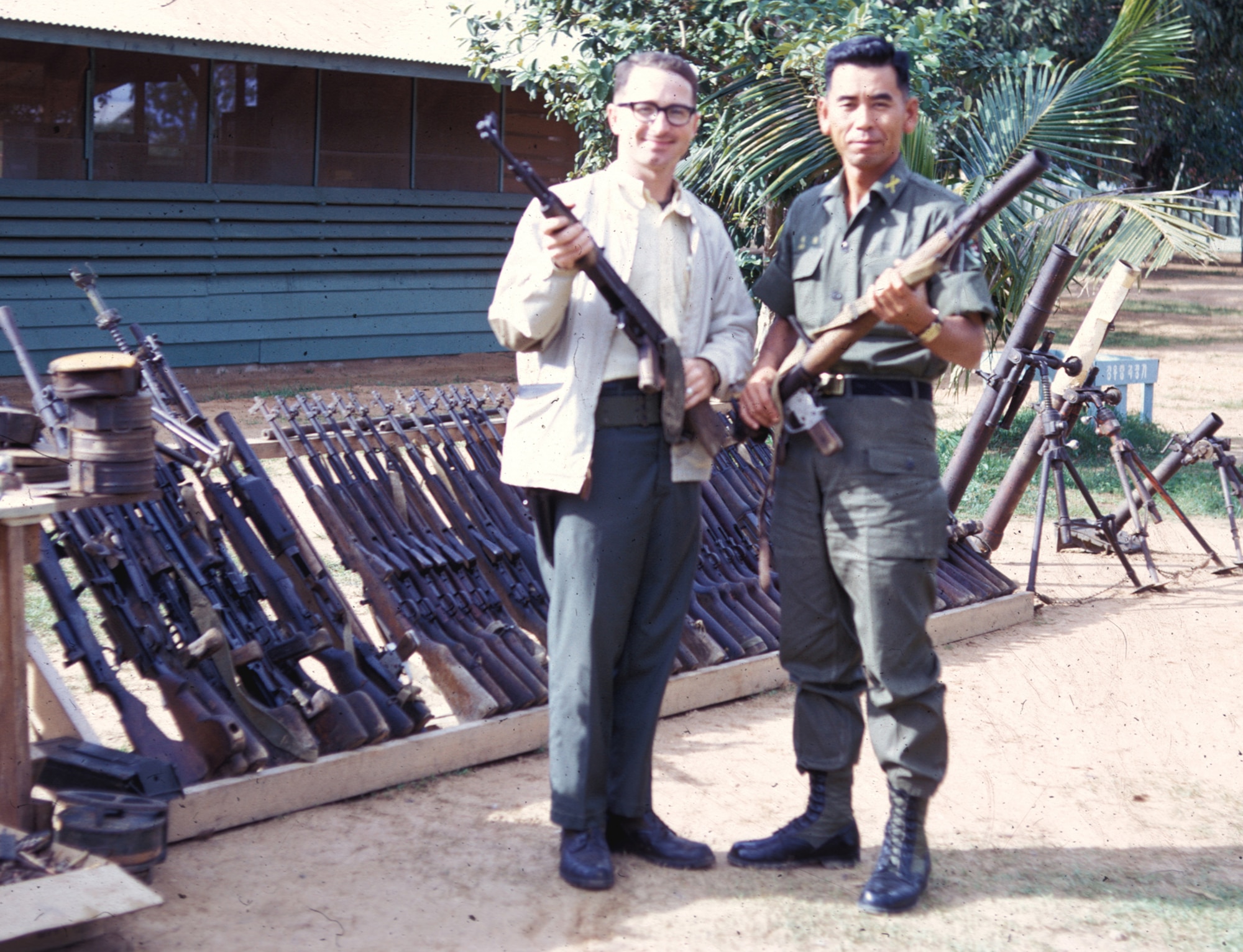 Air Force Office of Special Investigations (OSI) agent SrA Richard D. Emmons (l) and Republic of Korea Army Colonel Lee (r) display weapons captured from the enemy near Phu Cat Air Base. Though not part of the Security Police, Air Force OSI agents gathered valuable intelligence that helped in the defense of U.S. Air Force air bases. (U.S. Air Force photo).