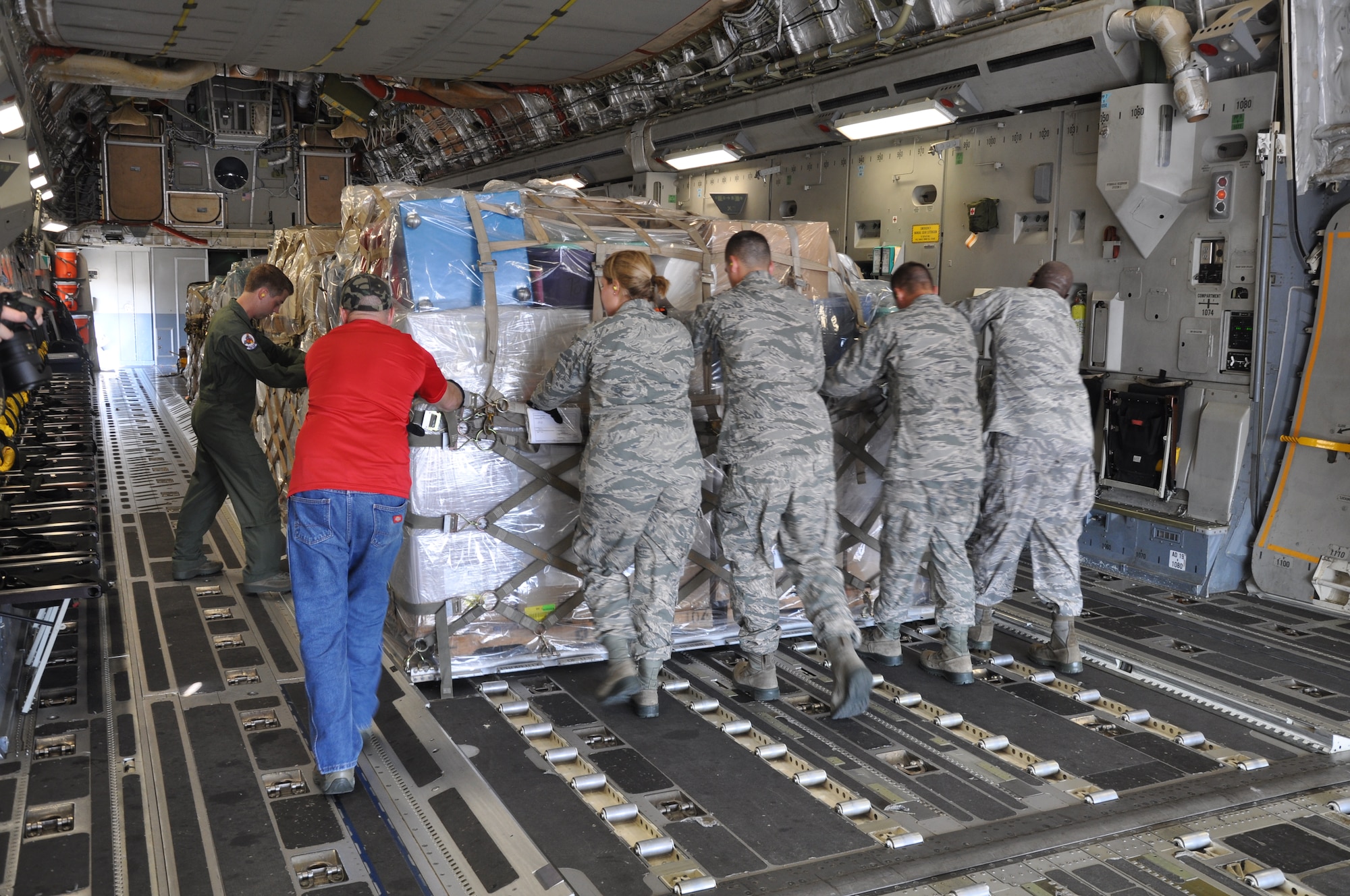 Airmen from the 25th Aerial Port Squadron at Maxwell Air Force Base, Ala. load humanitarian cargo on a C-17 Globemaster III from Joint Base Charleston, S.C. for Labor Day trip to Soto Cano Air Base, Honduras.