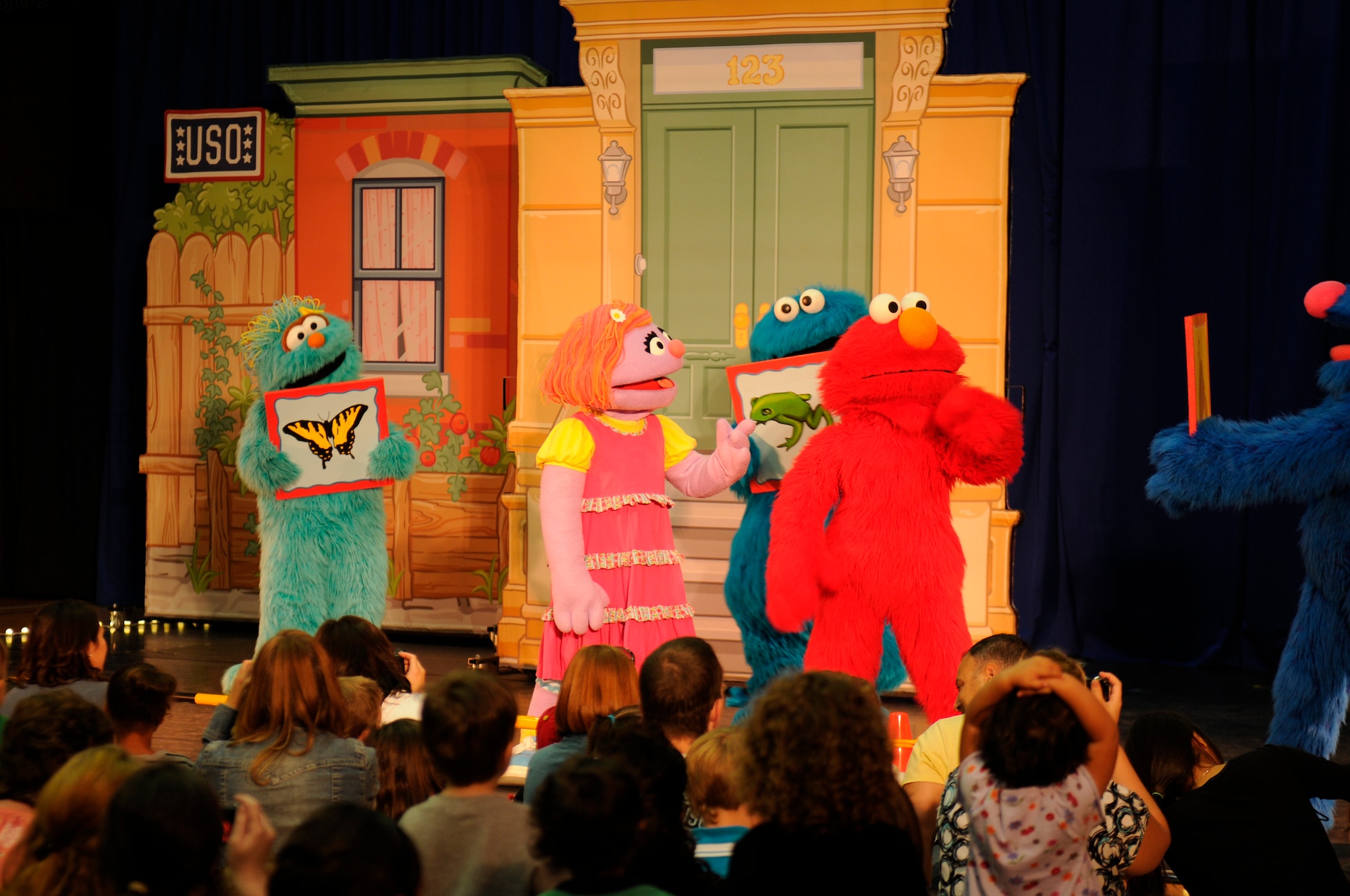 SPANGDAHLEM AIR BASE, Germany -- Military members and their families watch as Sesame Street characters perform here during the Sesame Street/USO Experience for Military Families tour Sept. 2 Skelton Memorial Fitness Center . Elmo and his Sesame Street pals perform at installations all around the world. The tour focuses on the challenges families face during deployments. (U.S. Air Force photo/Airman 1st Class Brittney Frees)