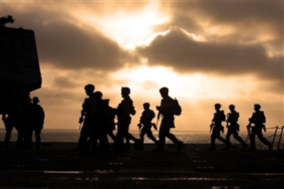 U.S. Marines move to a firing line while conducting marksmanship training on the flight deck of USS New Orleans off the coast of southern California, Sept. 4, 2011. The Marines are assigned to the 11th Marine Expeditionary Unit's maritime raid force.