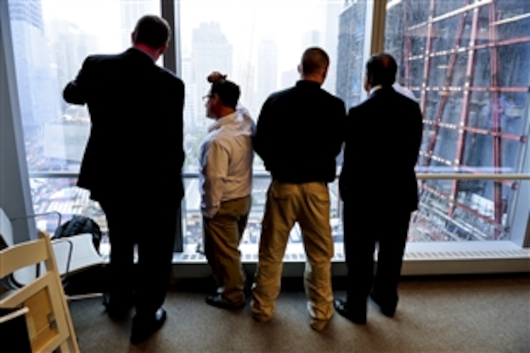 From a nearby building, Defense Secretary Leon E. Panetta, right, observes the 9/11 Memorial site and construction zone at One World Trade Center in New York with members of Helmets to Hardhats, a program that supports veterans transitioning to jobs in the construction industry, Sept. 6, 2011.  