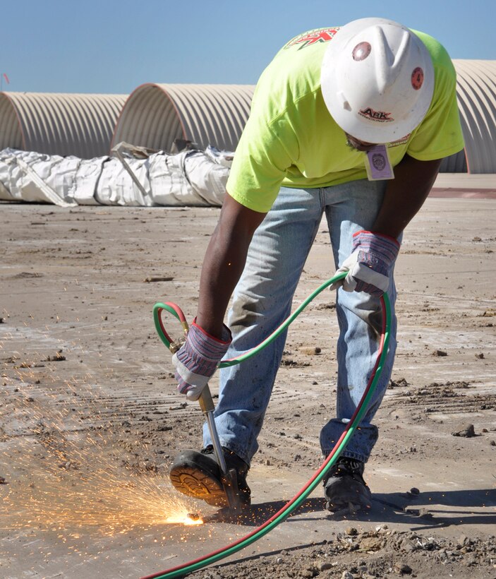 In preparation for a new tarmac and aircraft shelters, contract workers from ARK Wrecking tear down F-16 hard shelters and burn off the remaining anchor bolts at the 138th Fighter Wing, Oklahoma Air National Guard base in Tulsa, Ok.  (U.S. Air Force Photo by Master Sergeant Preston Chasteen)