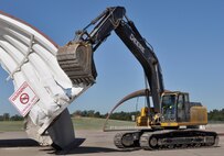 In preparation for a new tarmac and aircraft shelters, contract workers from ARK Wrecking tear down F-16 shelters at the 138th Fighter Wing, Oklahoma Air National Guard base in Tulsa, OK.  (U.S. Air Force Photo by Master Sergeant Preston Chasteen)
