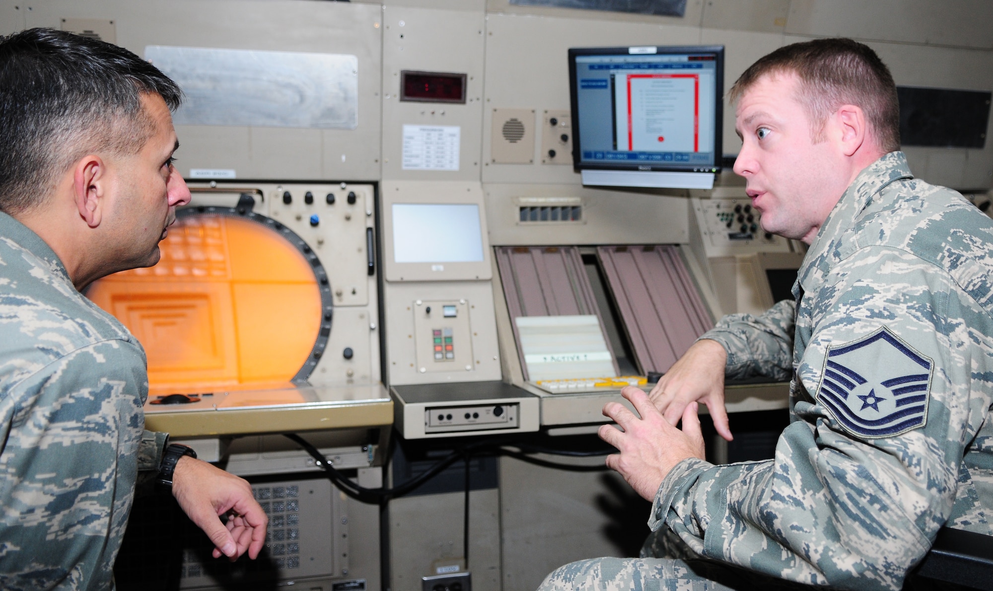 Master Sgt. Richard Turner, 52nd Operations Support Squadron assistant ground control approach chief controller, right, tells Col. David Julazadah, 52nd Fighter Wing vice commander, about the airfield operations flight mission here Aug. 18. Colonel Julazadah visited the 52nd OSS as part of a familiarization tour where he spoke face-to-face with Saber Airman about what they do to provide combat power and deliver full spectrum support to the Air Force. (U.S. Air Force photo/Airman 1st Class Matthew B. Fredericks)