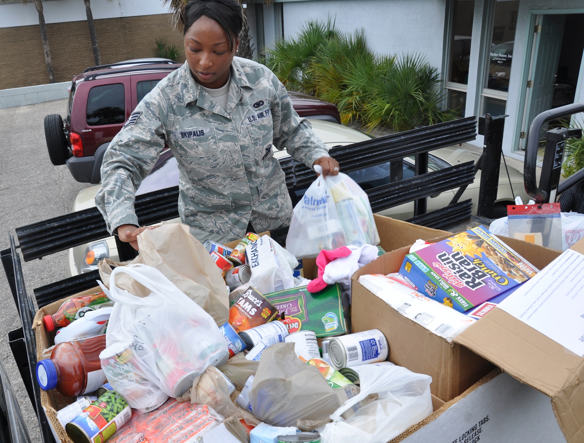 Staff Sgt. Avery Skipalis, 371st Special Operations Combat Training Squadron combat arms instructor, picks up bags of canned food donations at a domestic violence center in Fort Walton Beach, Fla., Sept. 2, 2011. The Hurlburt Field community raised approximately 3,585 pounds of items during the two months of the 2011 Feds Feed Families food drive. (U.S. Air Force photo by Senior Airman Joe McFadden)