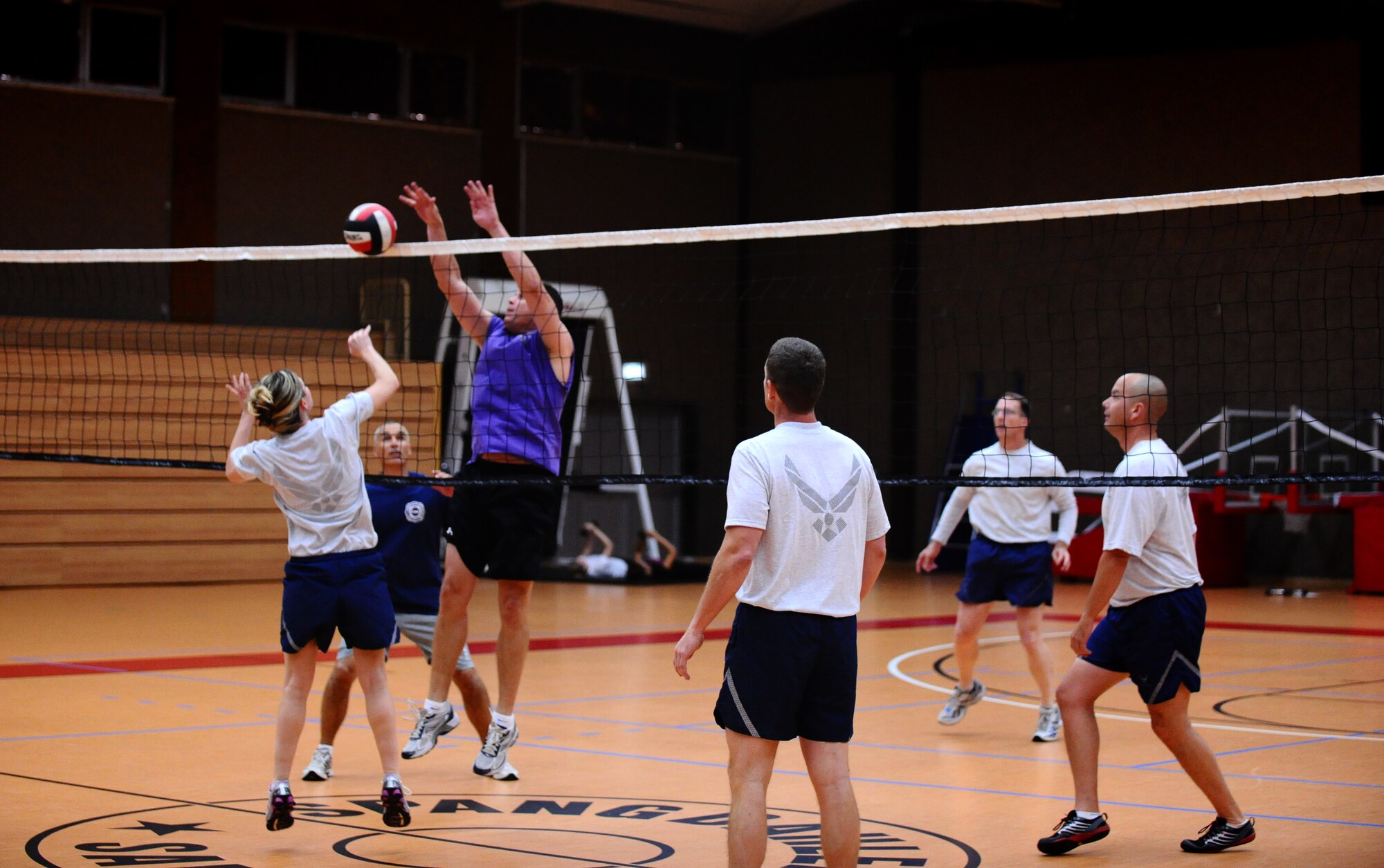 SPANGDAHLEM AIR BASE, Germany -- Catherine Logan, Spangdahlem Commanders, hits the ball over the net as Chad Ward, Spangdahlem Chiefs, attempts to block the ball during a friendly volleyball match at the Skelton Memorial Fitness Center here Aug. 30. The Chiefs defeated the Commanders 15-12 the first game and 15-3 the second game. (U.S. Air Force photo/Staff Sgt. Nathanael Callon)