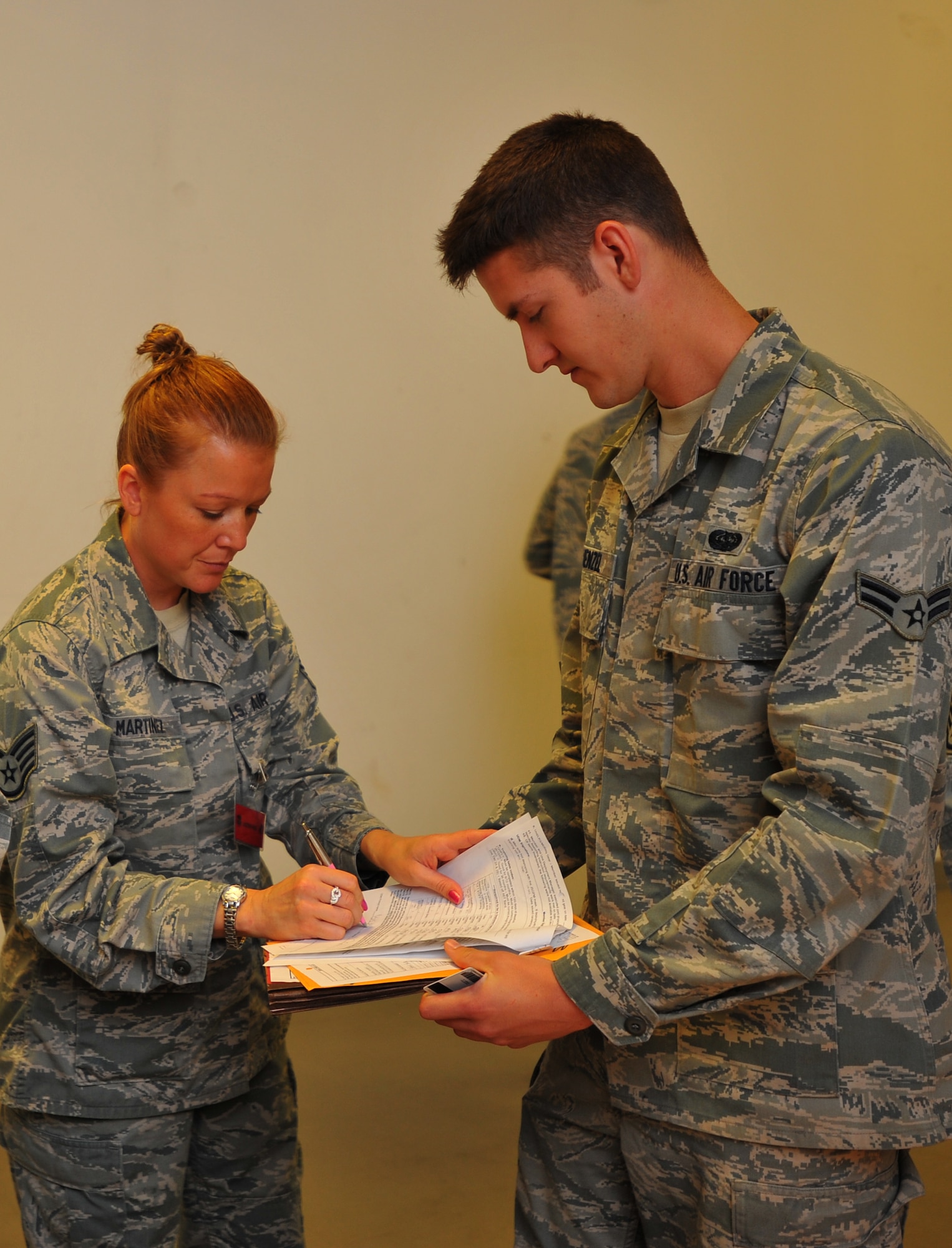 SPANGDAHLEM AIR BASE, Germany – Staff Sgt. Isis Martinez, left, 606th Air Control Squadron unit deployment manager, signs deployment paperwork for Airman 1st Class James Wenzel, 606th ACS, during a personnel deployment function line here Sept. 6. The PDF line consists of various base agencies that ensure deploying members have all necessary paperwork and checklists completed before leaving. (U.S Air Force photo/Airman 1st Class Dillon Davis)