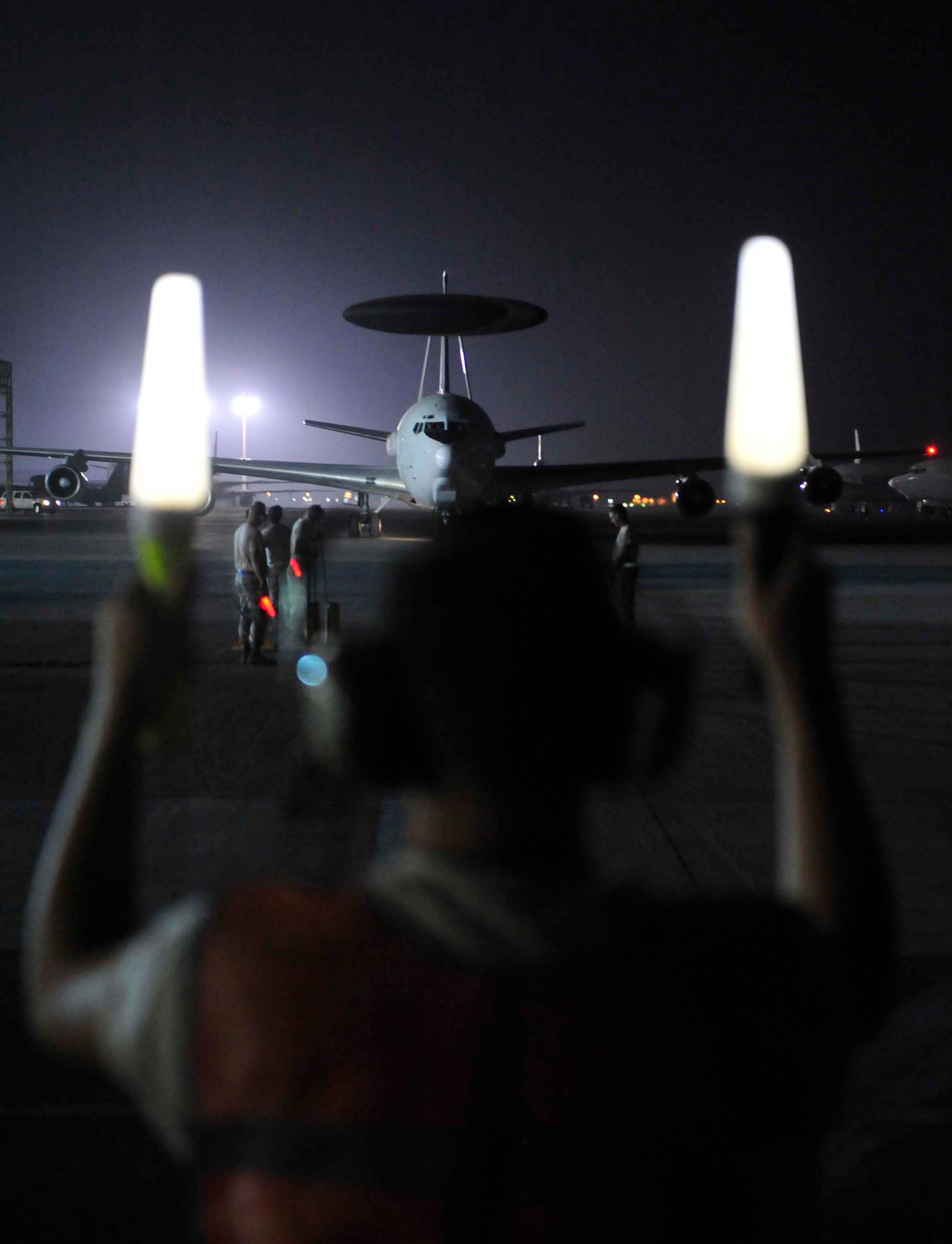 A flightline crew member at an air base in Southwest Asia marshals in the E-3 Sentry Airborne Warning and Control System, or AWACS, in which Maj. Jon Williams, a mission crew commander for the 963rd Expeditionary Airborne Air Control Squadron, flew a record-setting flight. Williams reached 10,195 flying hours on the AWACS Sept. 5, 2011, setting the all-time record for hours flown since the aircraft became operational in the Air Force in 1977. Williams hails from Colorado but now calls Edmond, Okla., his home. (U.S. Air Force photo/Tech Sgt. Patrick Mitchell)
