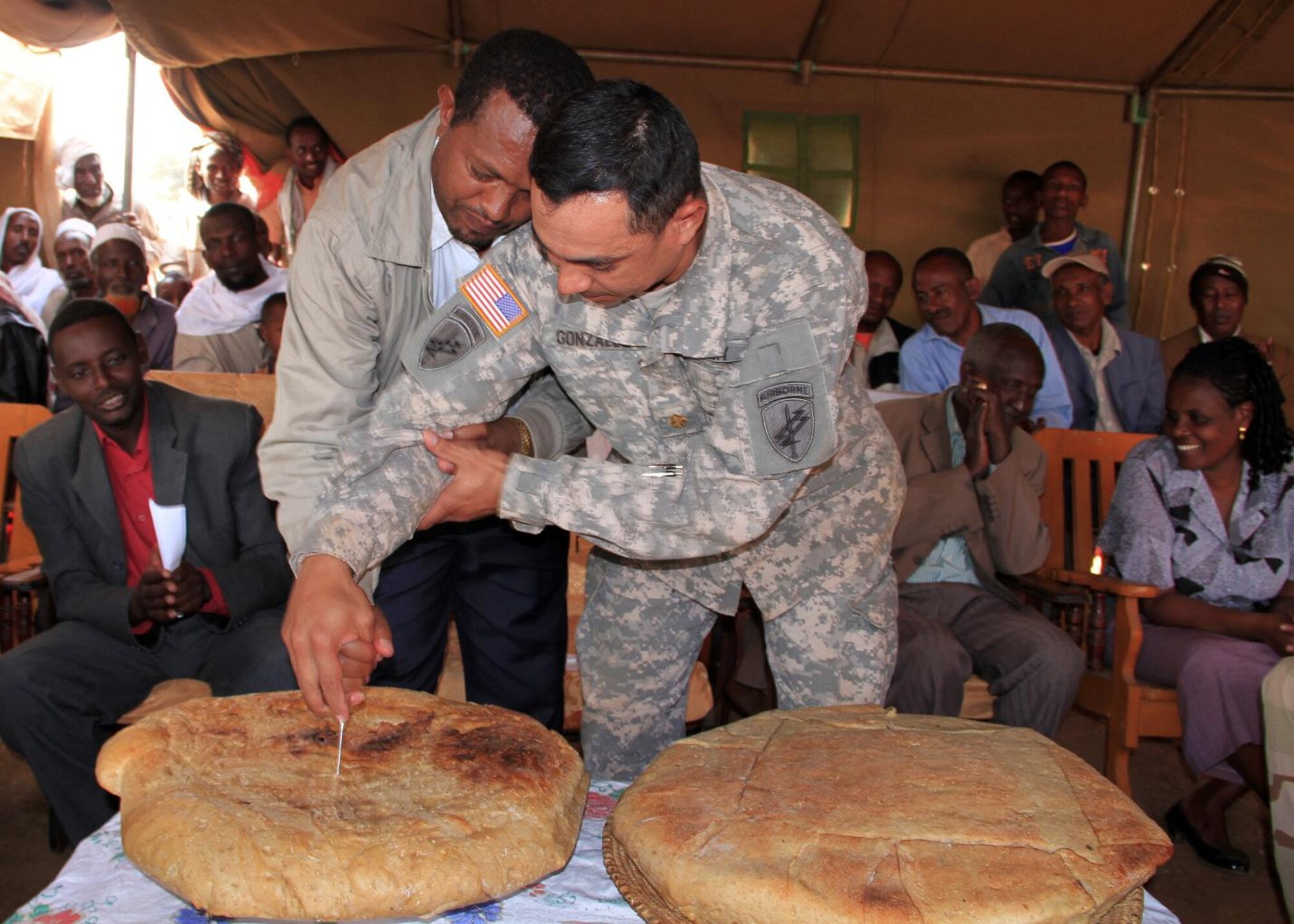Maj. Antonio Gonzales, civil affairs team chief, and Negele Mayor Ato Tesfaye Eyane conduct a bread cutting ceremony as part of the Negele Bridge dedication ceremony August 22, 2011. The people of Negele expressed their gratitude to their government for working with the U.S. to make this bridge a reality. (US Air Force photo by Capt Jennifer Pearson)