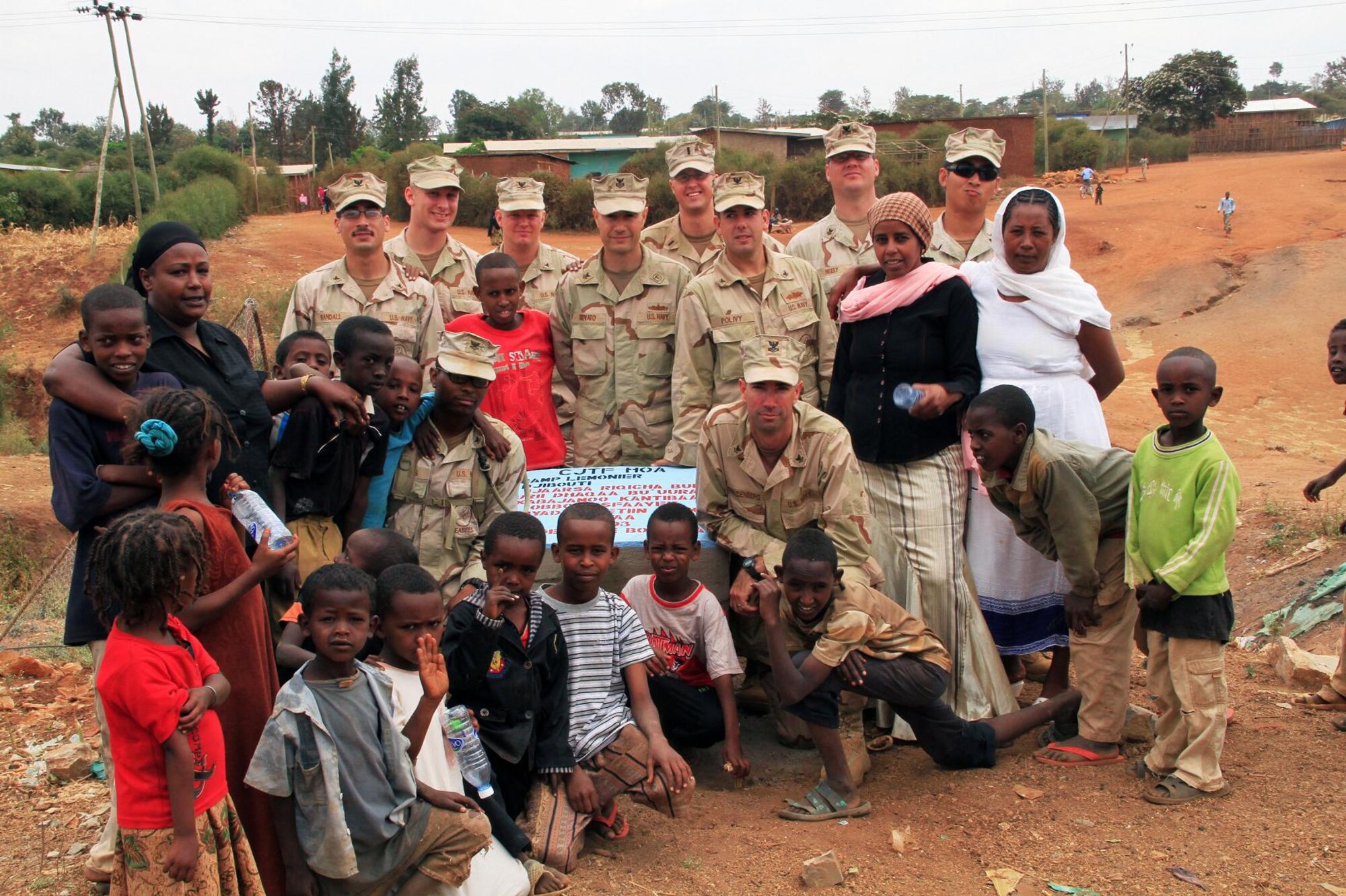 Women and children from Negele pose for a photo around the stone marker unveiled during a bridge dedication ceremony August 22, 2011.  The bridge connecting the villages of Negele and Borena will allow the villagers to cross the river during the rainy season for school, going to the market and seeking medical treatment. (US Air Force photo by Capt Jennifer Pearson)