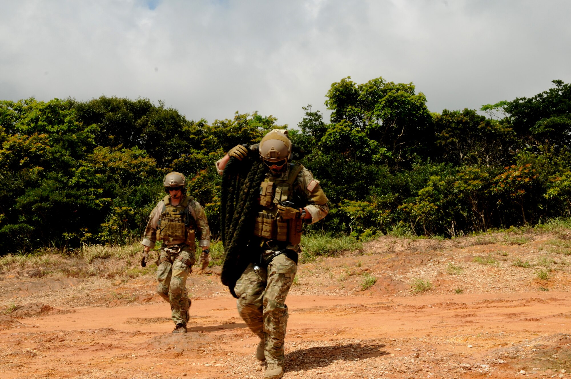 Capts. Matt Arnold and Brent McCall, both 31st Rescue Squadron combat rescue officers, advance to their designated target after being hoisted from an HH-60 Pave Hawk helicopter to a landing zone during a joint field training exercise off the coast of Okinawa Sept. 1. Members from the 31st and 33rd Rescue Squadrons trained together on water survival, search and rescue, close air support, and maritime defense and interdiction. (U.S. Air Force photo/Airman 1st Class Jarvie Z. Wallace) 