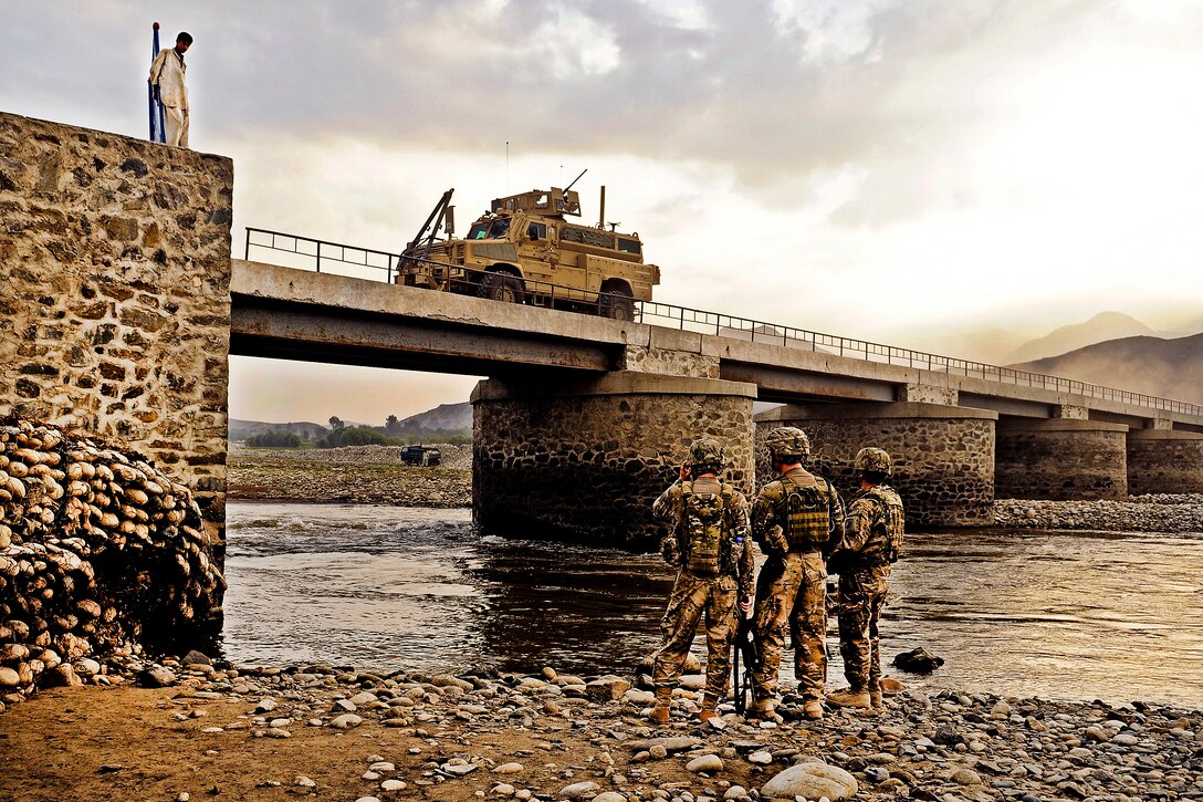 U.S. Air Force Capt. Jon Polston and Air Force 1st Lt. Scott Adamson inspect the underside of the Jugi bridge as traffic squeezes through the narrow roadway in Mehtar Lam in Laghman province, Afghanistan, Sept. 7, 2011. Polston and Adamson are engineers assigned to the Laghman Provincial Reconstruction Team.