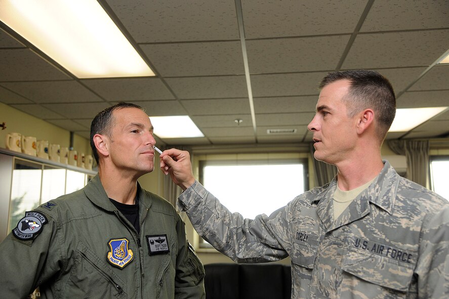 KUNSAN AIR BASE, Republic of Korea -- Col. Scott Pleus, 8th Fighter Wing commander, receives his ‘flu mist’ from Staff Sgt. Christopher Corley, 8th Medical Operations Squadron immunizations NCO in charge, here Sept. 7. The 8th Medical Group is administering flu shots and mist from 7 a.m. to 5 p.m., Sept. 13, at the base theater. (U.S. Air Force photo/Staff Sgt. Rasheen Douglas)