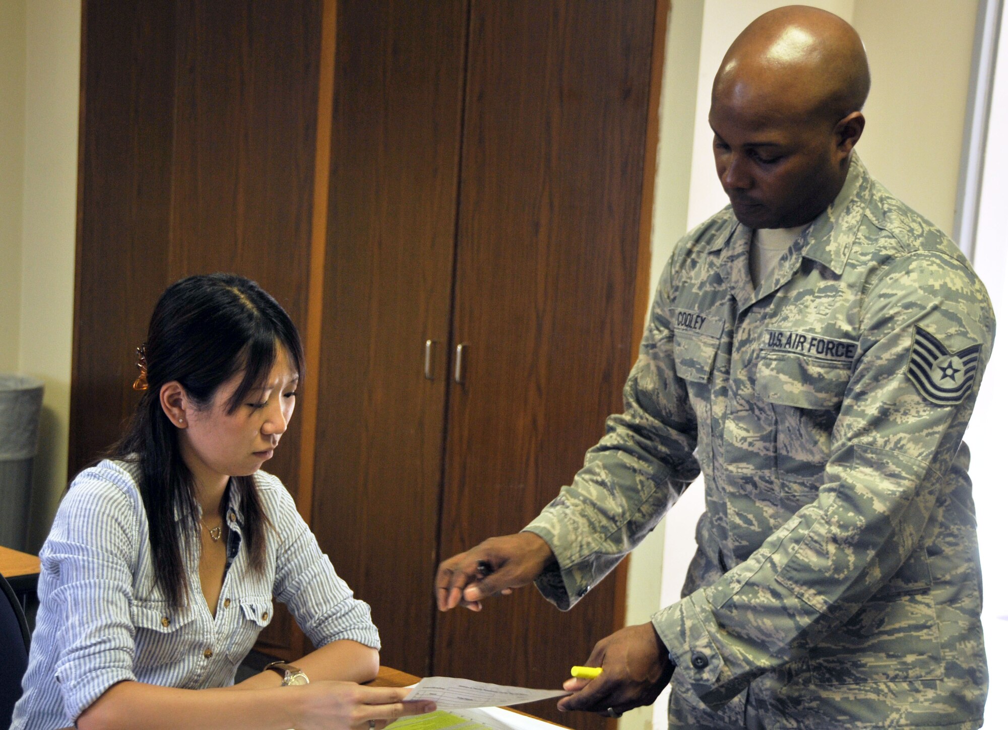 YOKOTA AIR BASE, Japan -- Tech. Sgt. Jonathan Cooley, Yokota Airman & Family Readiness Center readiness NCO in charge, talks to Akane Mason about opportunities available to her during her husband's deployment. The A&FRC offers multiple programs before, during and after deployment to assist military members and their families. (U.S. Air Force photo/Airman 1st Class Desiree Economides)