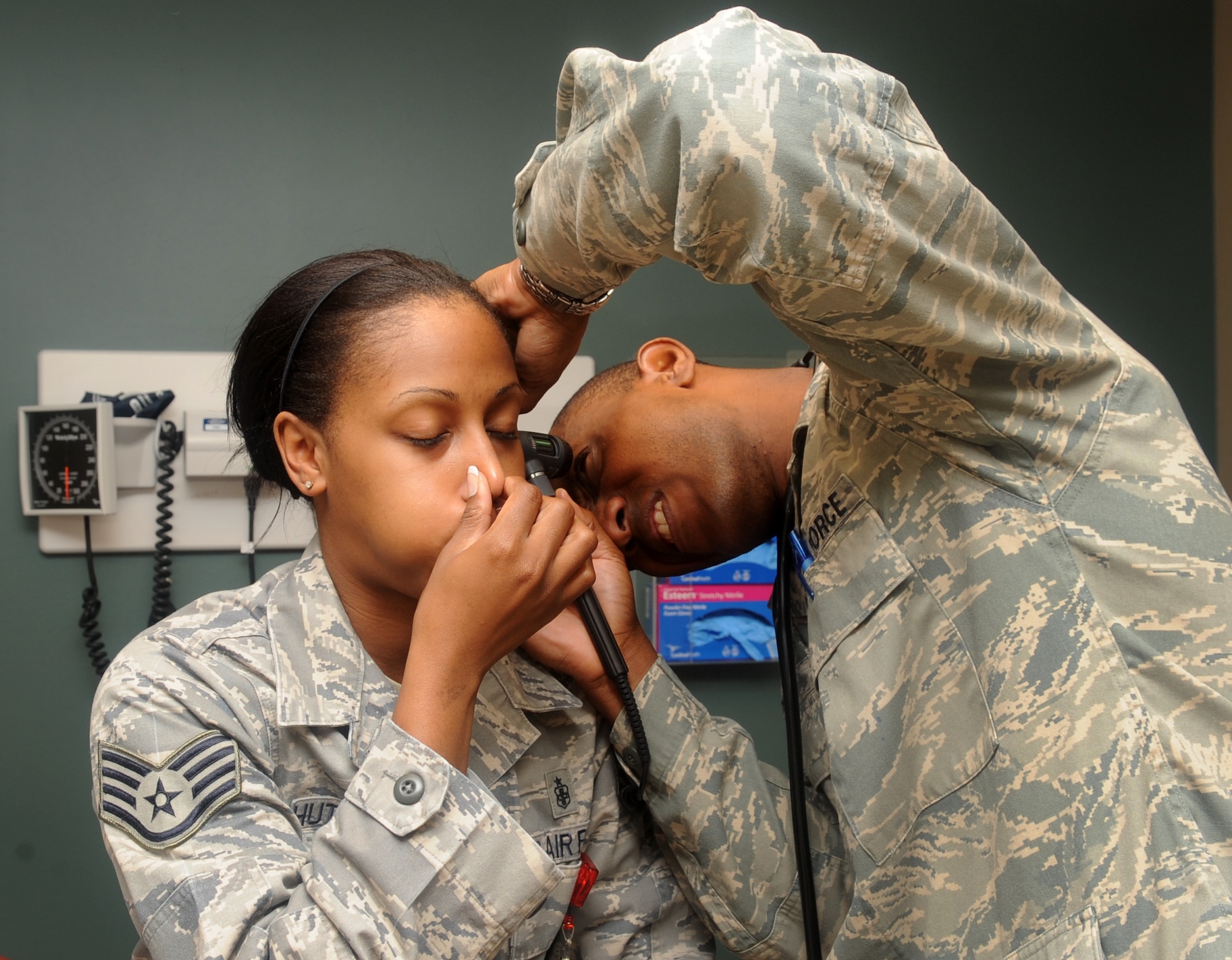 Staff Sgt. Netasha Hutto-Harris, 2nd Medical Support Squadron, holds her nose as Capt. Mark Dudley, 2nd Medical Operations Squadron physician, examines the inside of her ear. The primary care managers at the base family health clinic see a variety of medical cases - from sinus infections to muscular injuries - every day. (U.S. Air Force photo/Senior Airman Kristin High) (RELEASED)
