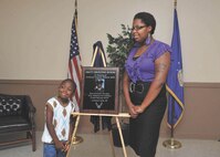 Son, Nathaniel, and daughter, Dania, stand next to the memorial plaque dedicated to their father, Tech. Sgt. Maurice Britt, who was killed by a drunk driver April 5, 2009. (U.S. Air Force photo/Alan Boedeker)