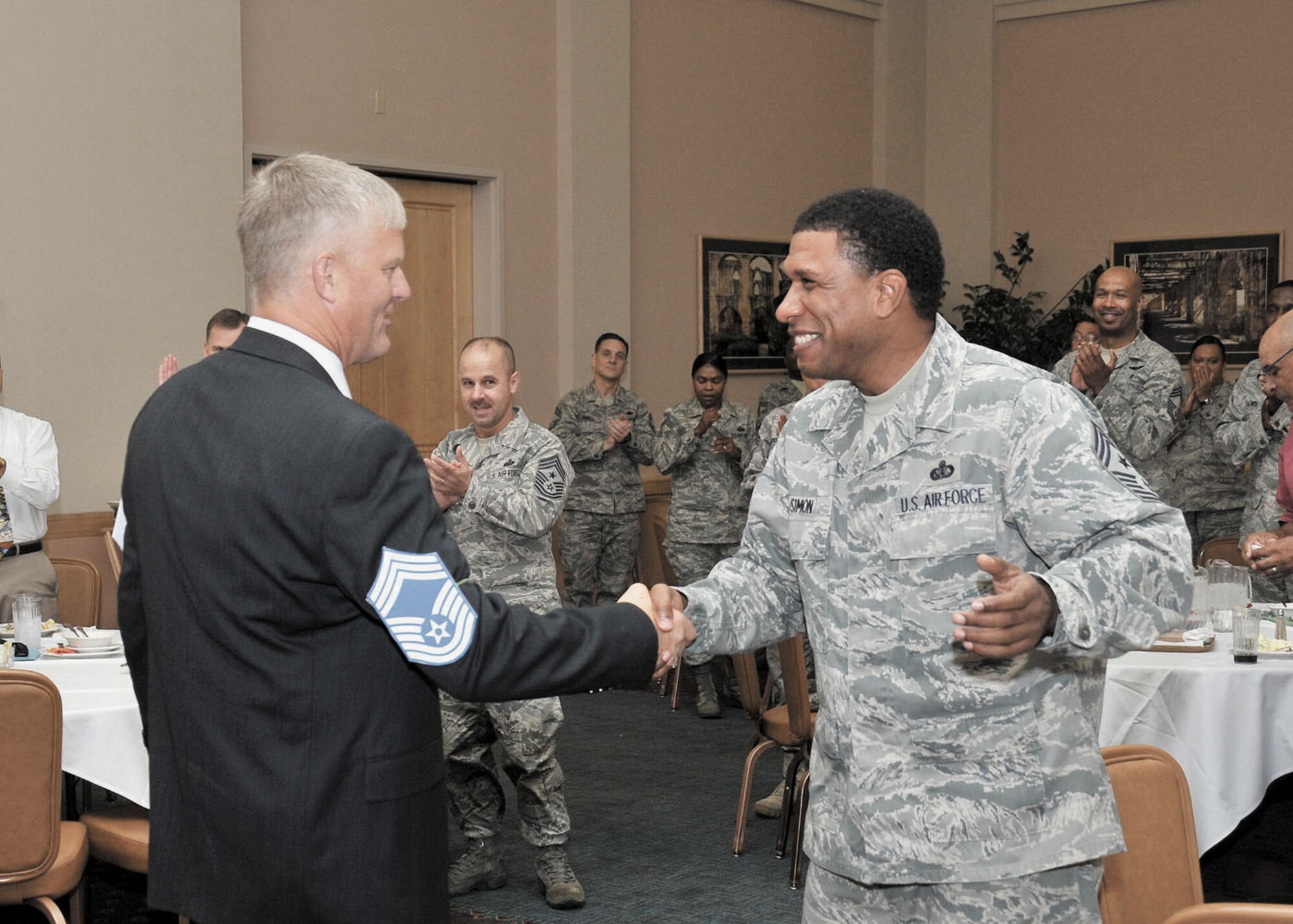 Col. William H. Mott V, former 37th Training Wing commander, is congratulated by Command Chief Master Sgt. Jay Simon soon after his selection ceremony as an honorary chief master sergeant. Simon was Mott’s top enlisted advisor during his tenure as commander of the 37 TRW. (U.S. Air Force photo/Alan Boedeker)