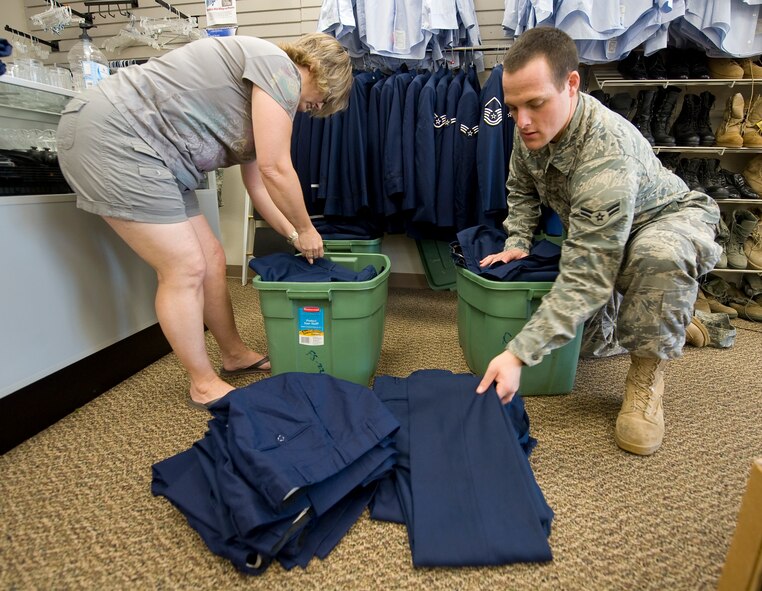 Stefanie Markin, Airman's Attic manager, assists Airman 1st Class Jonathon Crouch, 2nd Force Support Squadron, as he searches for blues pants in the Airman's Attic on Barksdale Air Force Base, La., Sept. 8. The Airman's Attic takes donations and offers merchandise free of charge to Airmen in the grades of E-1 through E-4. (U.S. Air Force photo/Senior Airman Chad Warren)