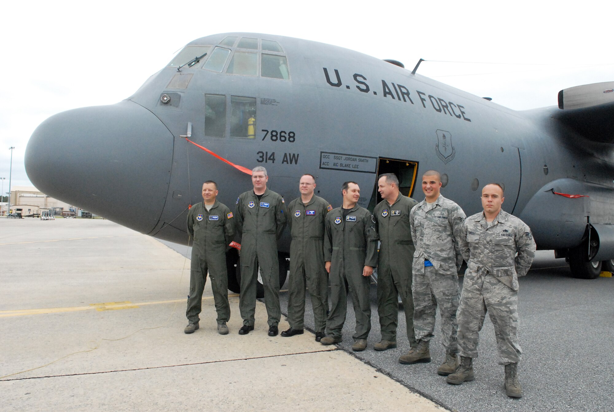 Crew members of the final flight of C-130E #63-7868, line up for a photo in front of the aircraft. U. S. Air Force photo by Sue Sapp