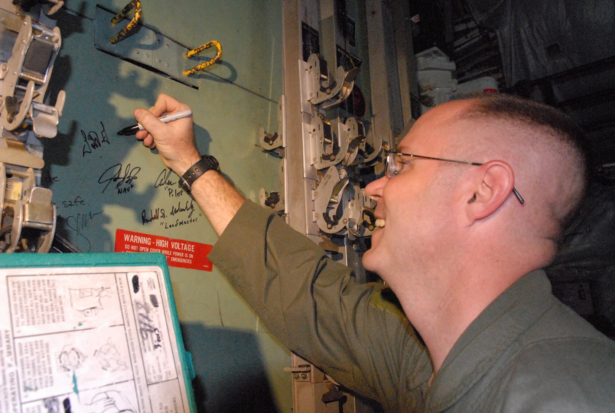 TSgt. Todd Gaff, flight engineer and one of the crew members on the last flight of C-130E #63-7868 signs his name inside the aircraft. U. S. Air Force photo by Sue Sapp 