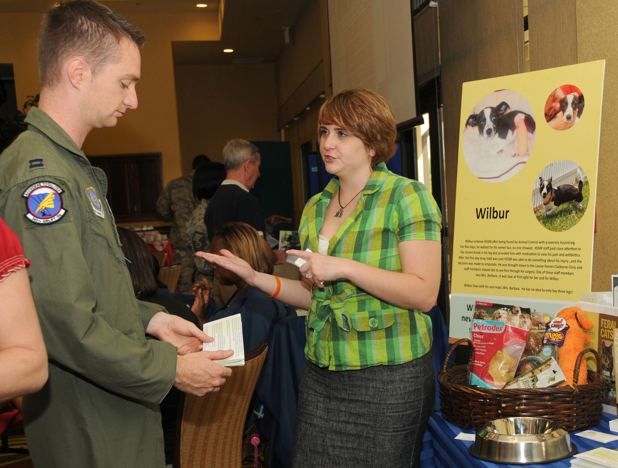 Capt. Chris Casler, left, 345th Airlift Squadron, learns about the Humane Society of South Mississippi from its marketing specialist, Krystyna Czczechowki during the Sept. 1 kickoff breakfast for the regional Combined Federal Campaign.  (U.S. Air Force photo by Kemberly Groue)
