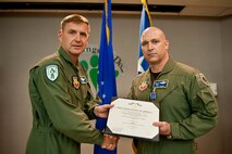 U.S. Air Force Maj. Gen. Stephen Hoog, 9th Air Force commander, presents a Distinguished Flying Cross Medal with valor certificate to Maj. Kirk Adams, 41st Rescue Squadron HH-60 pilot, at Moody Air Force Base, Ga., Sep. 7, 2011. Adams earned the medal when he suppressed armed enemies and performed a critical casualty evacuation April 4, 2009, near Kajaki, Afghanistan. (U.S. Air Force photo by Staff Sgt. Jamal D. Sutter/Released)