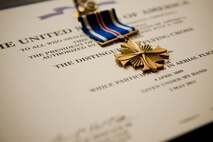 A Distinguished Flying Cross Medal rests on its certificate before the start of a presentation ceremony at Moody Air Force Base, Ga., Sep. 7, 2011. The medal was presented to U.S. Air Force Maj. Kirk Adams, 41st Rescue Squadron HH-60 pilot, for his actions while executing a critical casualty evacuation April 4, 2009, near Kajaki, Afghanistan. (U.S. Air Force photo by Staff Sgt. Jamal D. Sutter/Released)