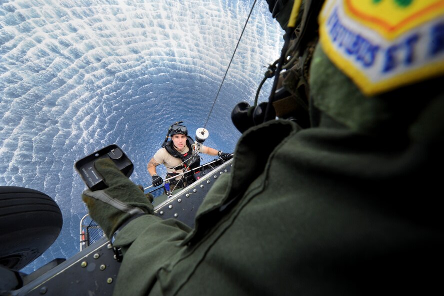 Staff Sgt. Jacob Schaumberg is hoisted onboard an HH-60 Pave Hawk by Master Sgt. John Durbin during a joint field-training exercise Sept. 1, 2011, off the coast of Okinawa. Airmen from two squadrons trained together on water survival; search and rescue; close-air support; and maritime defense and interdiction. Schaumberg is a pararescueman assigned to the 31st Rescue Squadron at Kadena Air Base, Japan, and Durbin is a flight engineer and superintendent assigned to the 33rd Rescue Squadron at Kadena AB. (U.S. Air Force photo/Airman 1st Class Jarvie Z. Wallace)