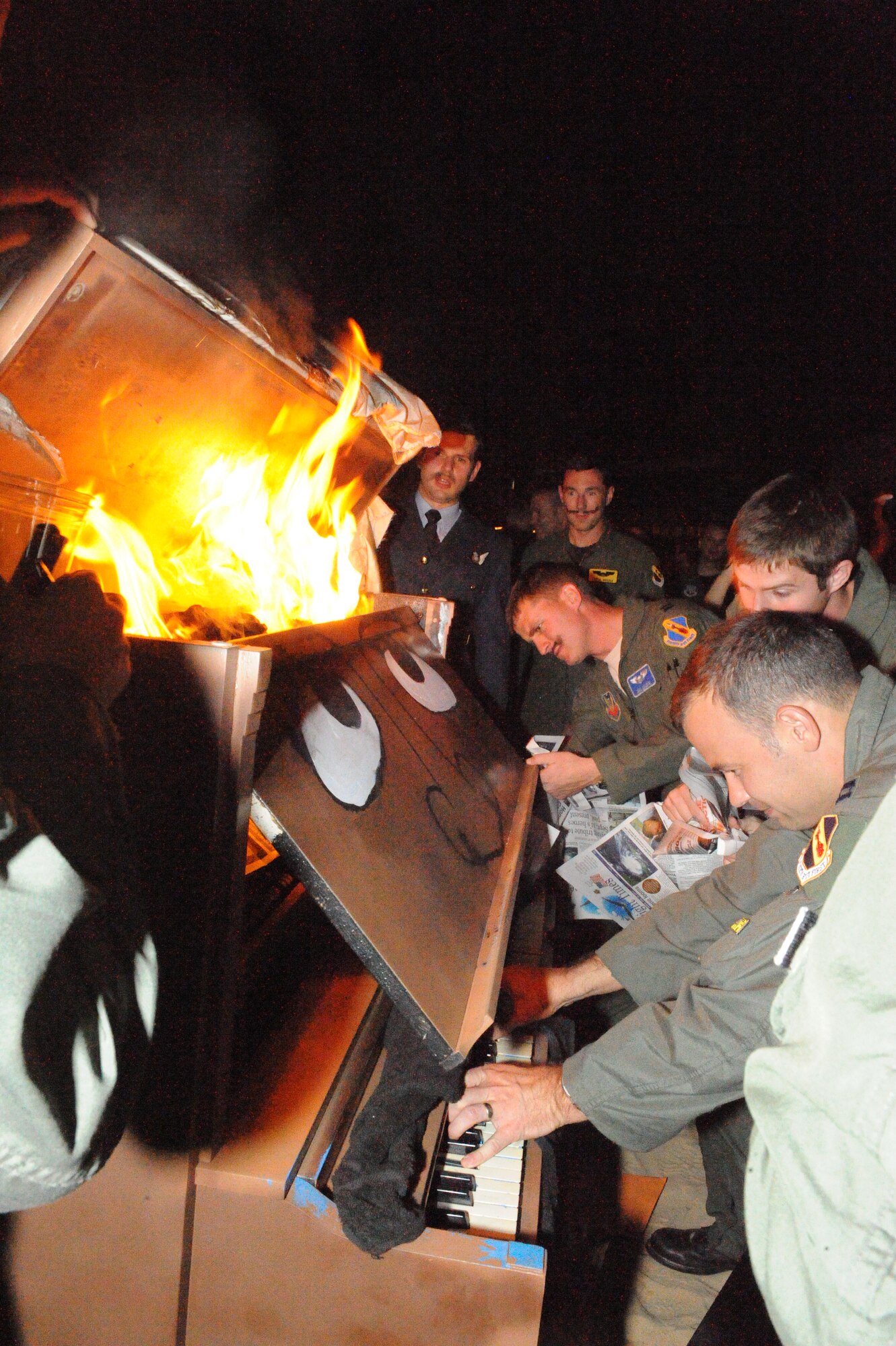 Captain Josh Aldus plays one last song as the first of many pianos are set on fire during the Battle of Britain commemoration party at the Spitfire Pub on Seymour Johnson Air Force Base, N.C., Sept. 1.  The origins of the tradition of burning a piano are disputed, but one commonly held belief is the piano is burned in memory of a downed Royal Air Force aviator.  The fallen pilot’s comrades burned the piano, deeming that no other could ever play as well as him.  Aldus is a weapons system operator from the 336th Fighter Squadron.  (U.S. Air Force photo by 2nd Lt. Keavy Rake/Released)