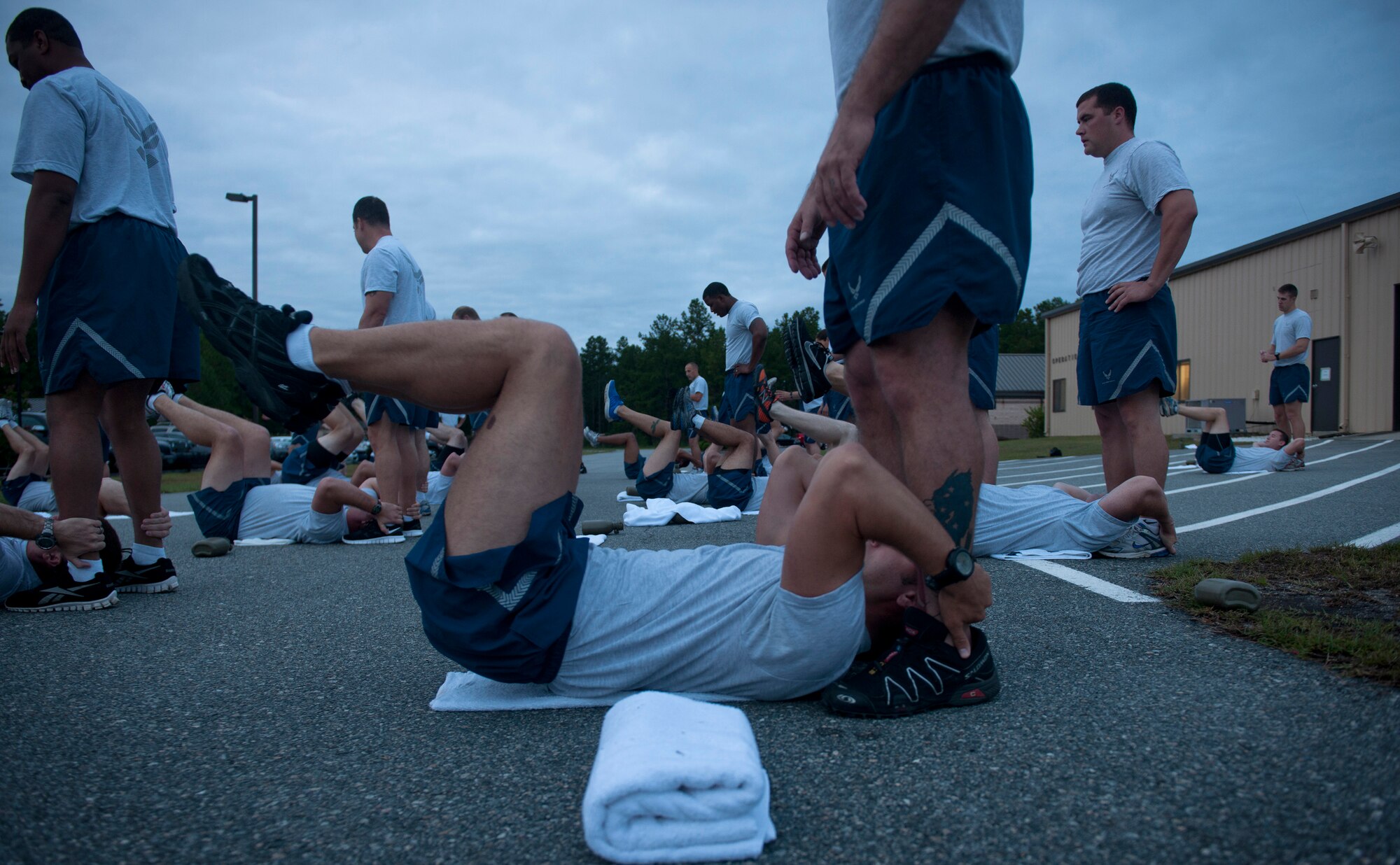 U.S. Air Force Airmen from the 820th Base Defense Group perform reverse crunches during Sergeant Rock physical training (PT) at Moody Air Force Base Ga., Sept. 6, 2011. Sergeant Rock PT is aimed to strengthen the core and upper body as well as mental toughness preparing individuals for their PT test. (U.S. Air Force photo by Airman 1st Class Joshua Green/Released)           

