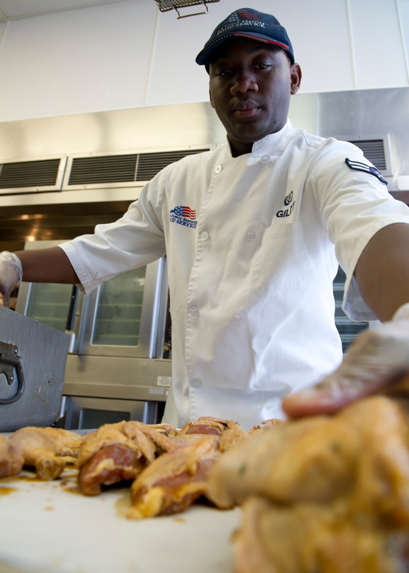 HOLLOMAN AIR FORCE BASE, N.M. -- U.S. Air Force Airman 1st Class Jeffrey Gilot, 49th Force Support Squadron food handler, lines up teriyaki chicken onto a cooking pan in preparation for dinner at the Shifting Sands Dining Facility Aug. 31, 2011. Gilot was awarded Chef of the Quarter after winning a cook-off competition, and was given the opportunity to cook alongside chefs at Stella Vita, a local restaurant. (U.S. Air Force photo by Senior Airman Veronica Stamps/Released)