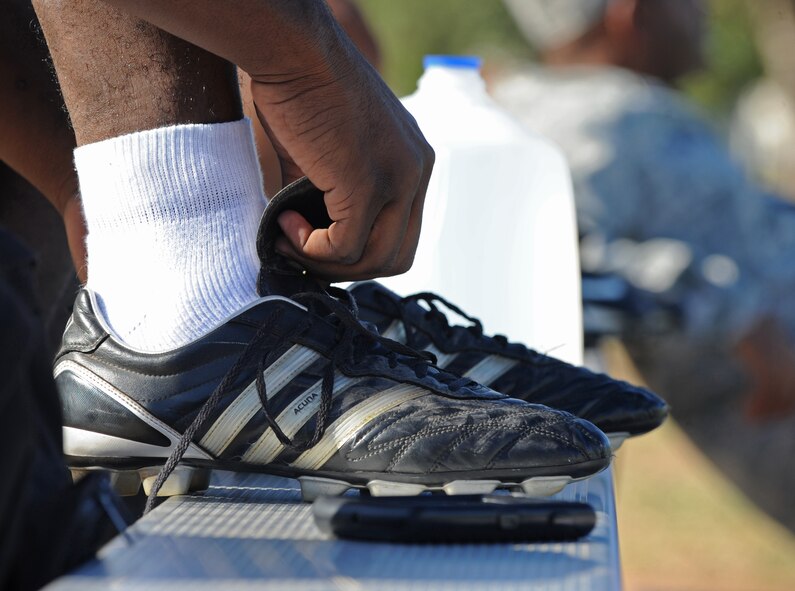 Airman 1st Class Marius Johnson, 2nd Logistics Readiness Squadron, puts on cleats before an intramural flag football game on Barksdale Air Force Base, La., Sept. 6.  Cleats are designed to help athletes gain traction on natural outdoor surfaces like grass and dirt. (U.S. Air Force photo/Airman 1st Class Micaiah Anthony)(RELEASED)