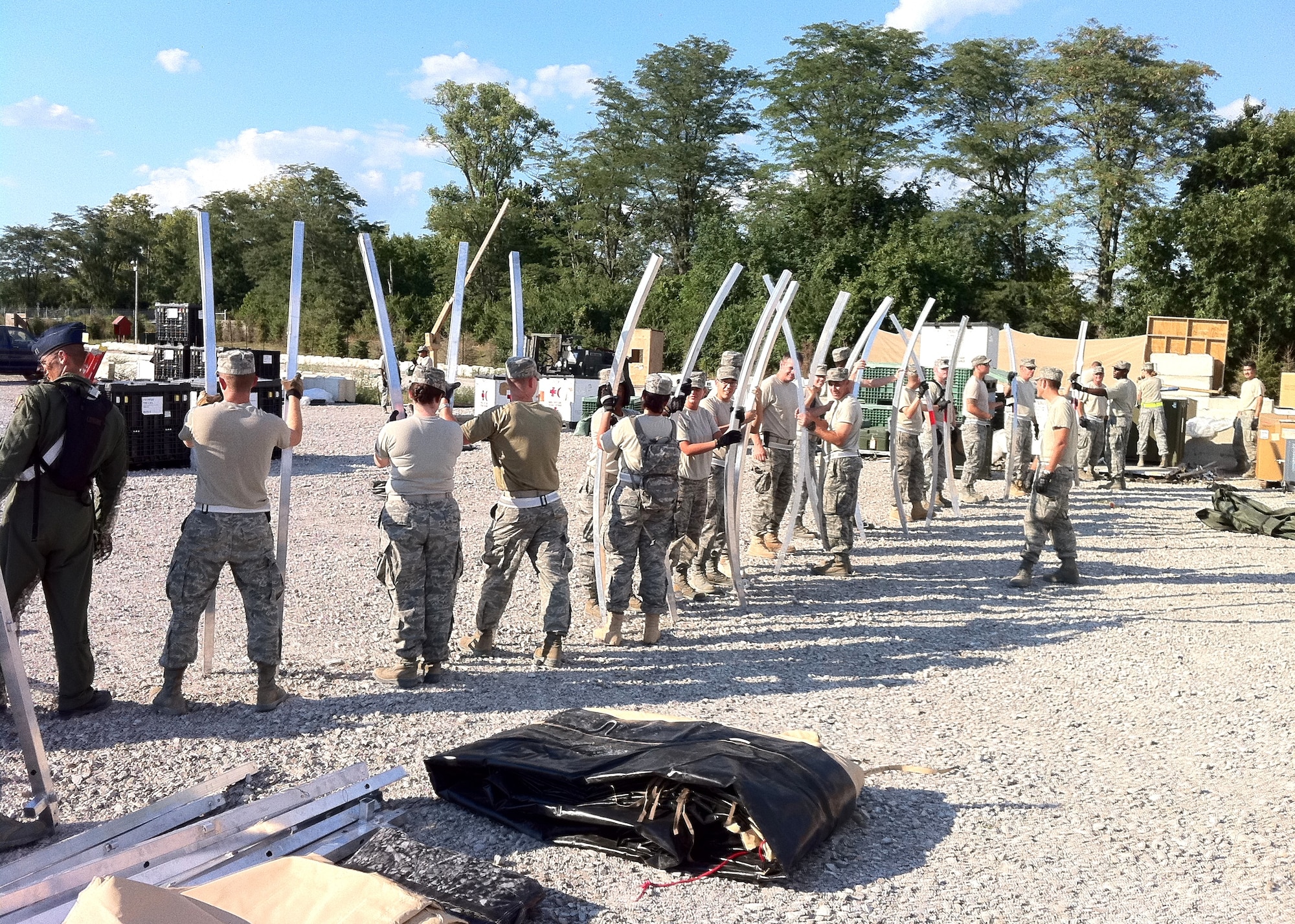 “Dragon Medics” dismantle the field hospital tents Aug. 23 at the conclusion of the exercise. Each curved piece formed the skeleton of the Alaskan Shelter tents. The team formed a “bucket brigade” to return the pieces to the shipping containers.  (U.S. Air Force photo by Lt. Col. (Dr.) Joseph Pocreva)