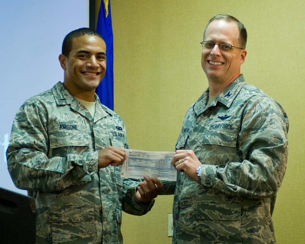 Col. Mark Weatherington, 28th Bomb Wing commander, presents 1st Lt. Richie Amisone, 28th Comptroller Squadron deputy flight commander financial analysis, his Combined Federal Campaign donation form at Ellsworth Air Force Base, S.D., Sept. 6, 2011. More than 200 CFC offices sprinkled throughout the country and internationally help raise money every year for non-profit organizations. (U.S. Air Force photo by Airman Alystria Maurer/Released)
