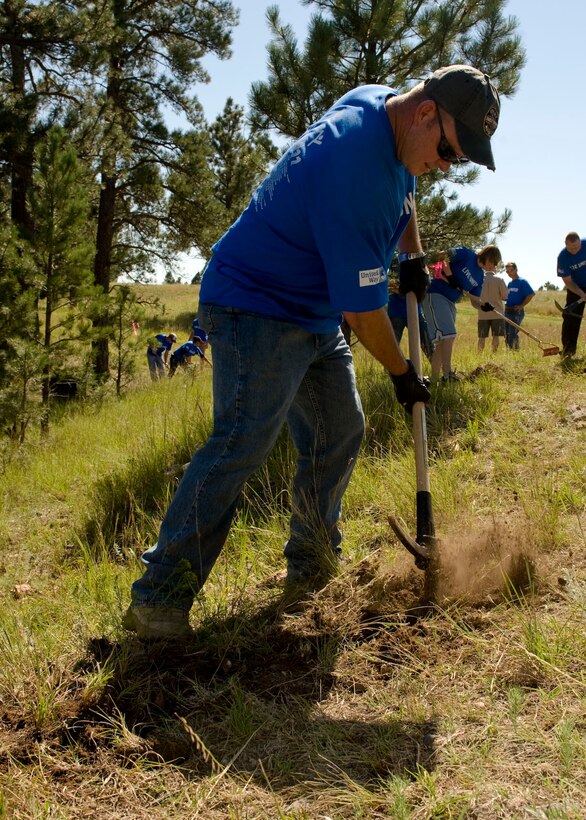 Master Sgt. Shane Johnson, 28th Munitions Squadron assistant flight chief, helps clear rocks from the ground at the Rapid City YMCA’s Giraffic Park in Hermosa, S.D., Sept. 1, 2011. Giraffic Park is a site where the YMCA hosts a children’s day camp. (U.S. Air Force photo by Airman 1st Class Kate Thornton/Released)