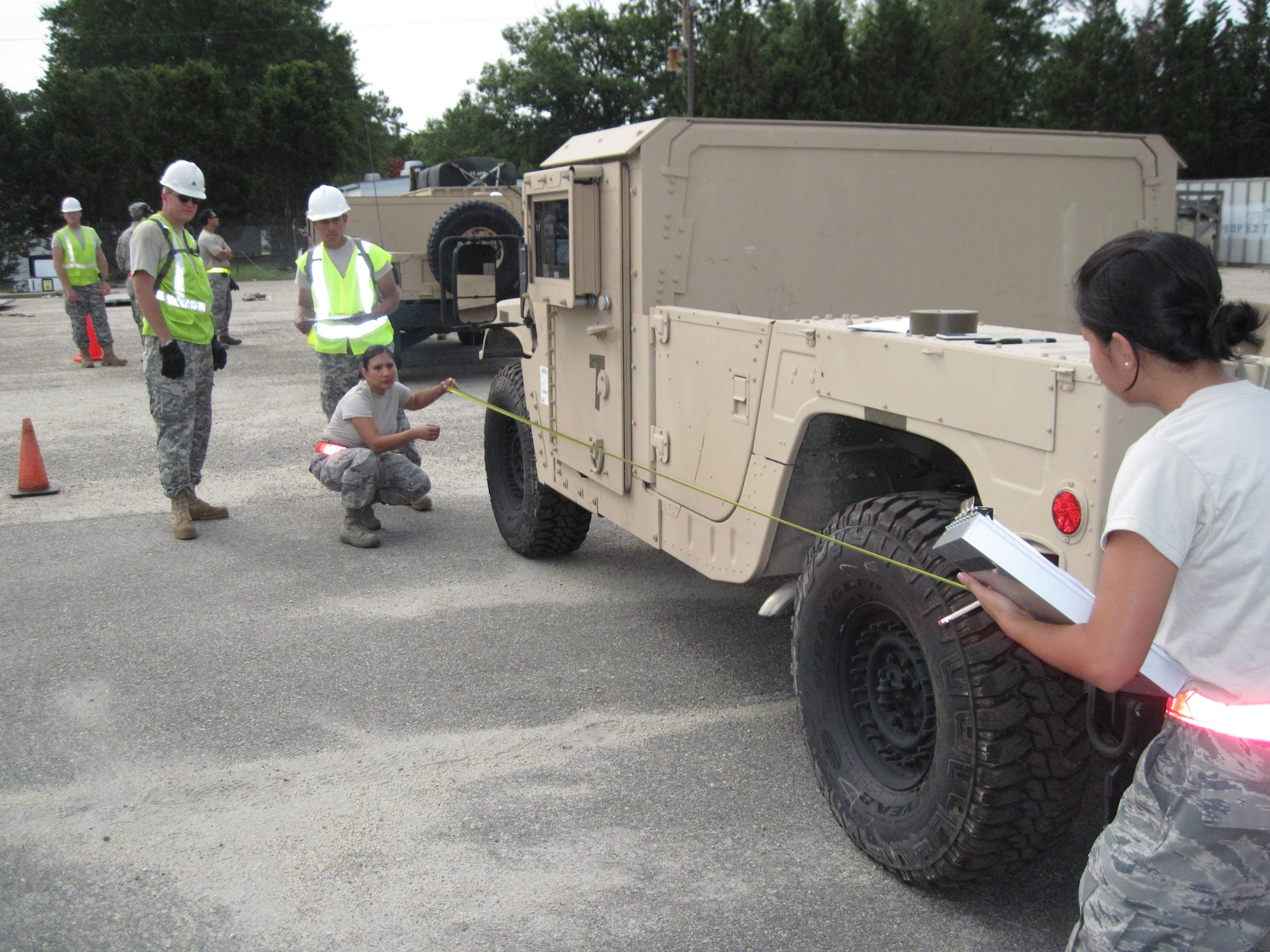 Staff Sgt. Isabel Arias (kneeling) and Staff Sgt. Roselle Cruz, 71st Aerial Port Squadron aerial porters, measure the overall length of a vehicle being in-checked prior to the joint inspection Aug. 4, 2011. The vehicles were processed during a joint, contingency-training exercise at Fort Eustis, Va. (U.S. Air Force Photo by Chief Master Sgt. Chris Alston/Released)