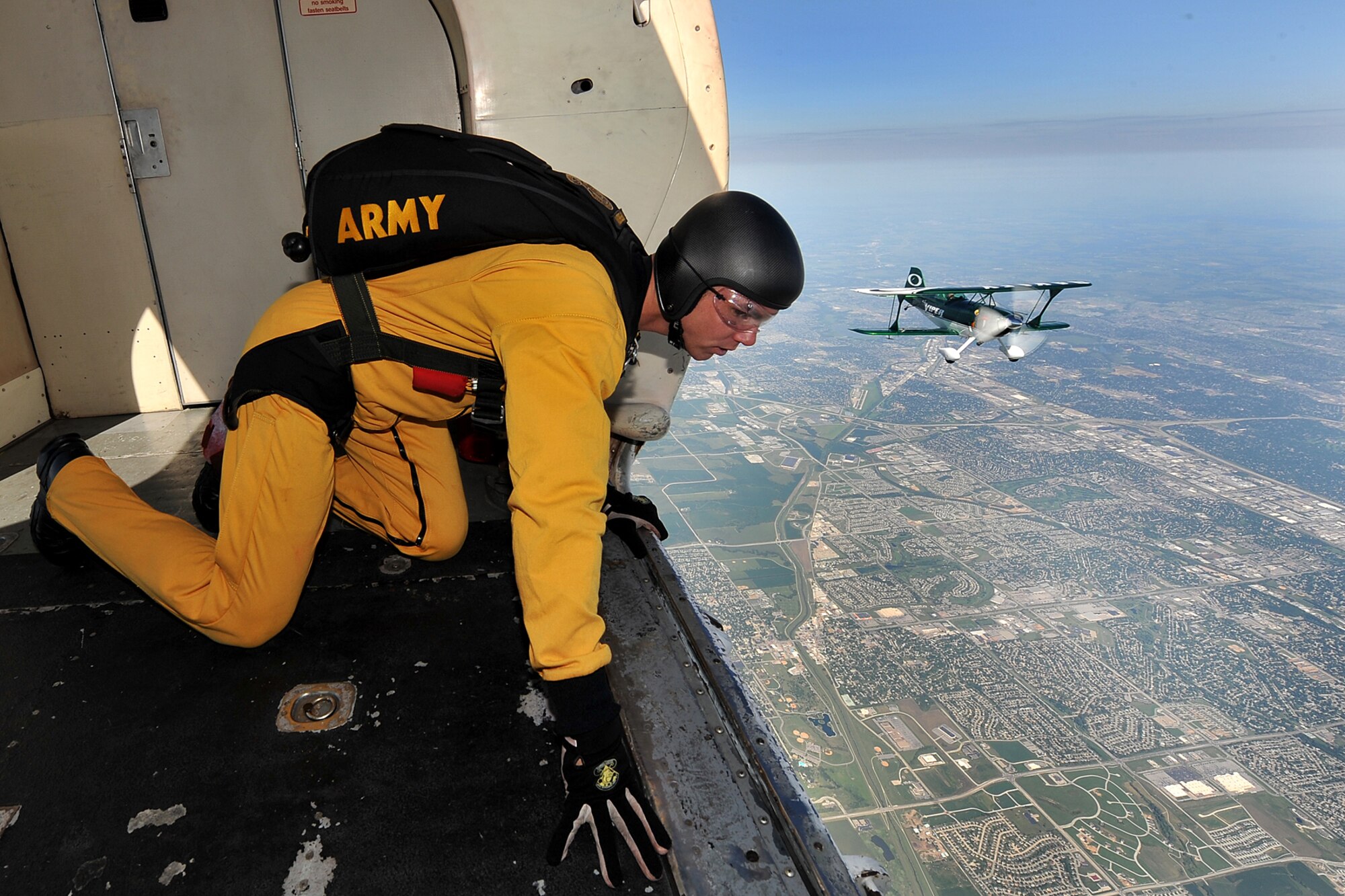 U.S. Army Sgt. Trevor Oppenborn, with the U.S. Army Golden Knights demonstration team, looks out in preparation for his parachute jump while Jason Newburg, Viper Airshows Pitts S2, flies beside the Fokker C-31A Troopship aircraft during the 2011 Defenders of Freedom Open House and Air Show at Offutt Air Force Base, Neb., Aug. 27. The Golden Knights have been performing at air shows since its inception in1961. (U.S. Air Force photo by Charles Haymond/Released)