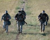 Senior Airman Patrick Gereben, Senior Airman Justin Mouton, Airman 1st Class Anthony Leopardi and Airman 1st Class Robert Berger, all with the 790th Missile Security Forces Squadron, don gas masks as they participate in the Ruck and Run event during Crow Creek Challenge here Aug. 25. (U.S. Air Force photo by Matt Bilden)