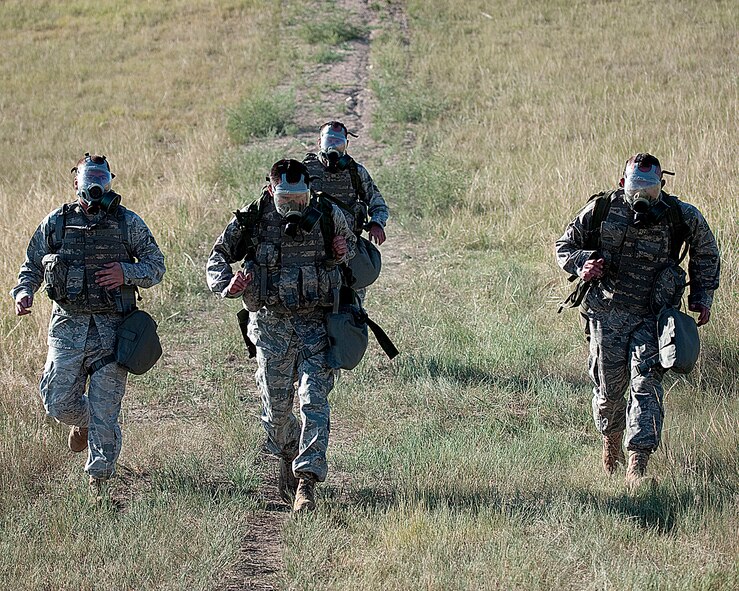 Senior Airman Patrick Gereben, Senior Airman Justin Mouton, Airman 1st Class Anthony Leopardi and Airman 1st Class Robert Berger, all with the 790th Missile Security Forces Squadron, don gas masks as they participate in the Ruck and Run event during Crow Creek Challenge here Aug. 25. (U.S. Air Force photo by Matt Bilden)