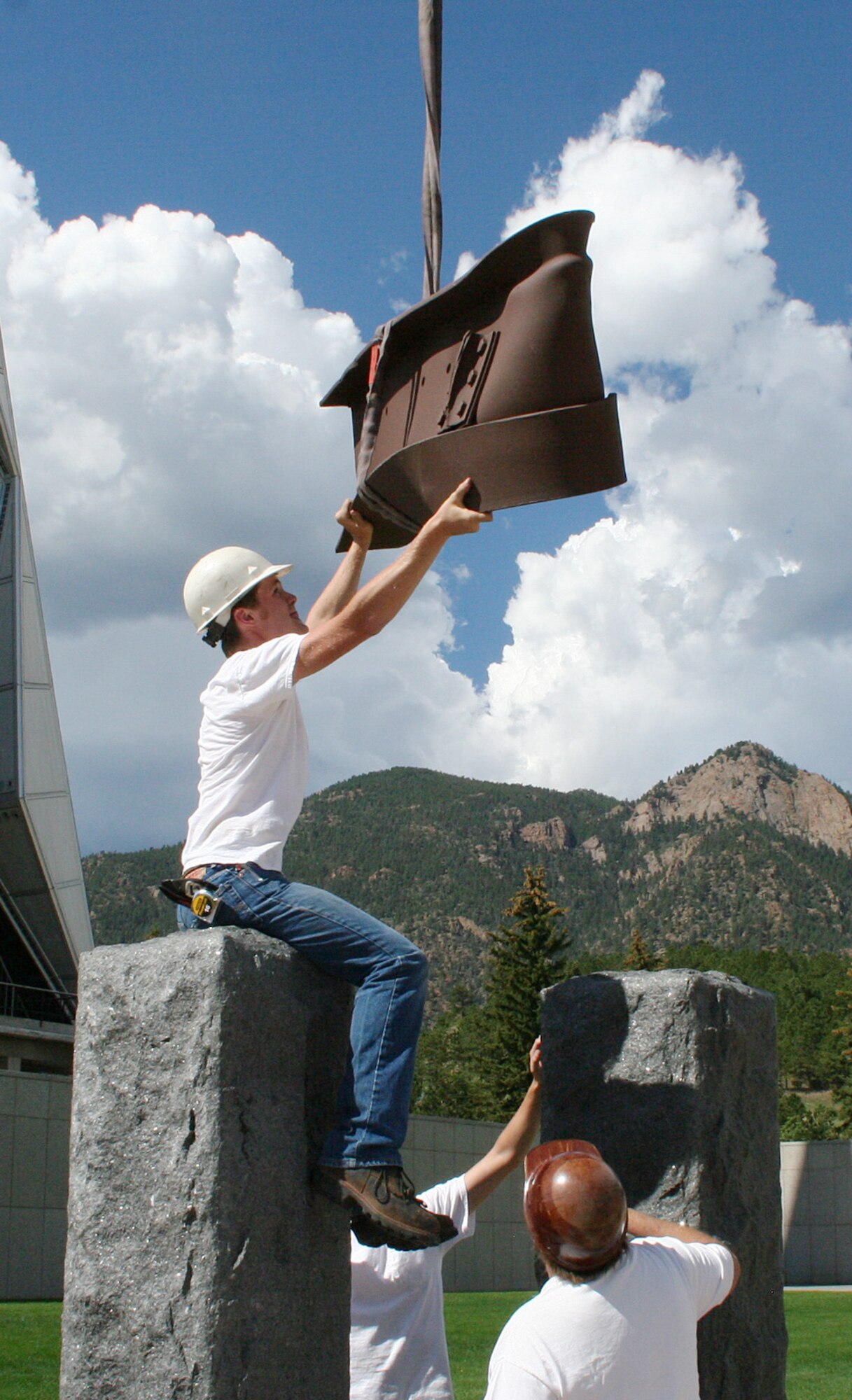 Workers lower a steel beam from the World Trade Center into position between two slabs of granite representing the Twin Towers in the Air Force Academy's Sept. 11 Memorial Aug. 24, 2011. The memorial is scheduled to be dedicated in a ceremony at the Academy Sept. 9. (U.S. Air Force photo/Paul Martin)