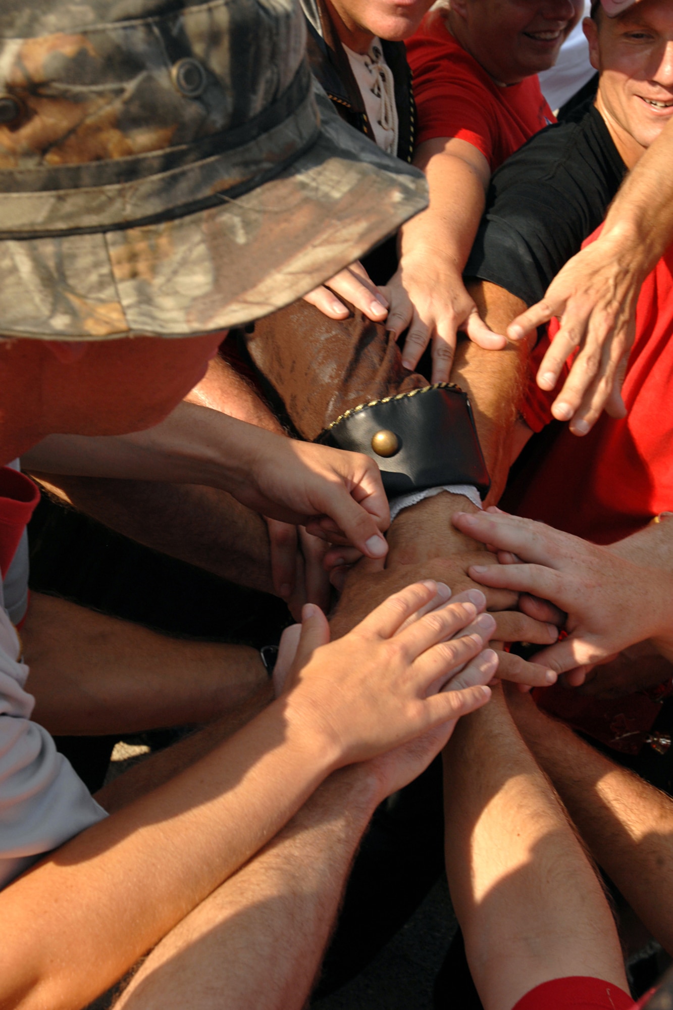 GRISSOM AIR RESERVE BASE, Ind. -- All hands front and center as the Fightin' Red Tags put their hands together as they cheer on their team after their victory over the Dark Side Aug. 13 in the 5th Annual Jovanovich Cup. Every year the Red Tags and the Dark Side meet on the field to battle it out for the trophy and bragging rights. This year the Red Tags edged the Dark Siders, 13-12. The event is held in memory of Lt. Col. George Jovanovich who died in a car accident in March 2006. (U.S. Air Force photo/Senior Airman Jami K. Lancette)