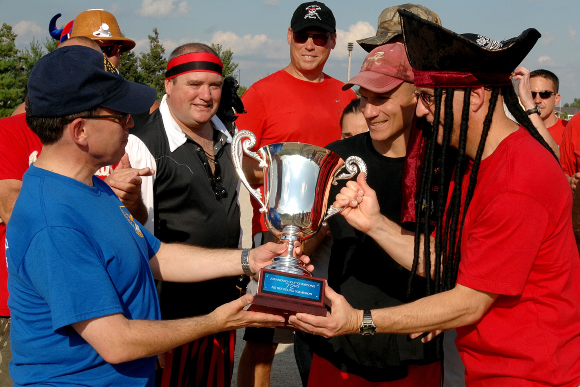 GRISSOM AIR RESERVE BASE, Ind. -- Lew Poore, Dark Side, hands over the Jovanovich Cup to Brian Stopher of the fightin' Red Tags, who accepts it after his teams impressive win during the 5th Annual Jovanovich Cup Aug. 13. Every year the Red Tags and the Dark Side battle it out in memory of Lt. Col. George Jovanovich who died in a car accident in March 2006. (U.S. Air Force photo/Senior Airman Jami K. Lancette)