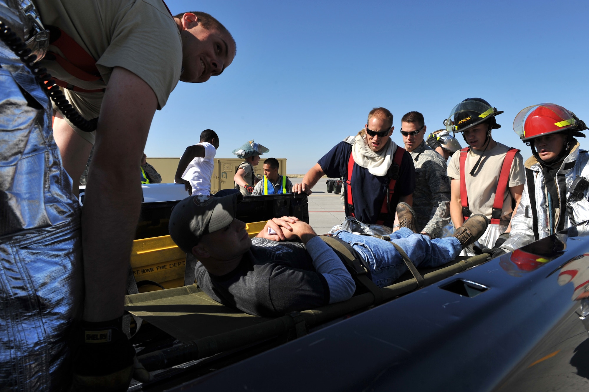 MOUNTAIN HOME AIR FORCE BASE, Idaho – Personnel from the base fire department lift a casualty from a simulated aircraft accident into a truck here, Sept. 1. The injured were placed in the bed of trucks and taken to the hospital for treatment due to ambulances being full. (U.S. Air Force photo by Airman 1st Class Heather Hayward)