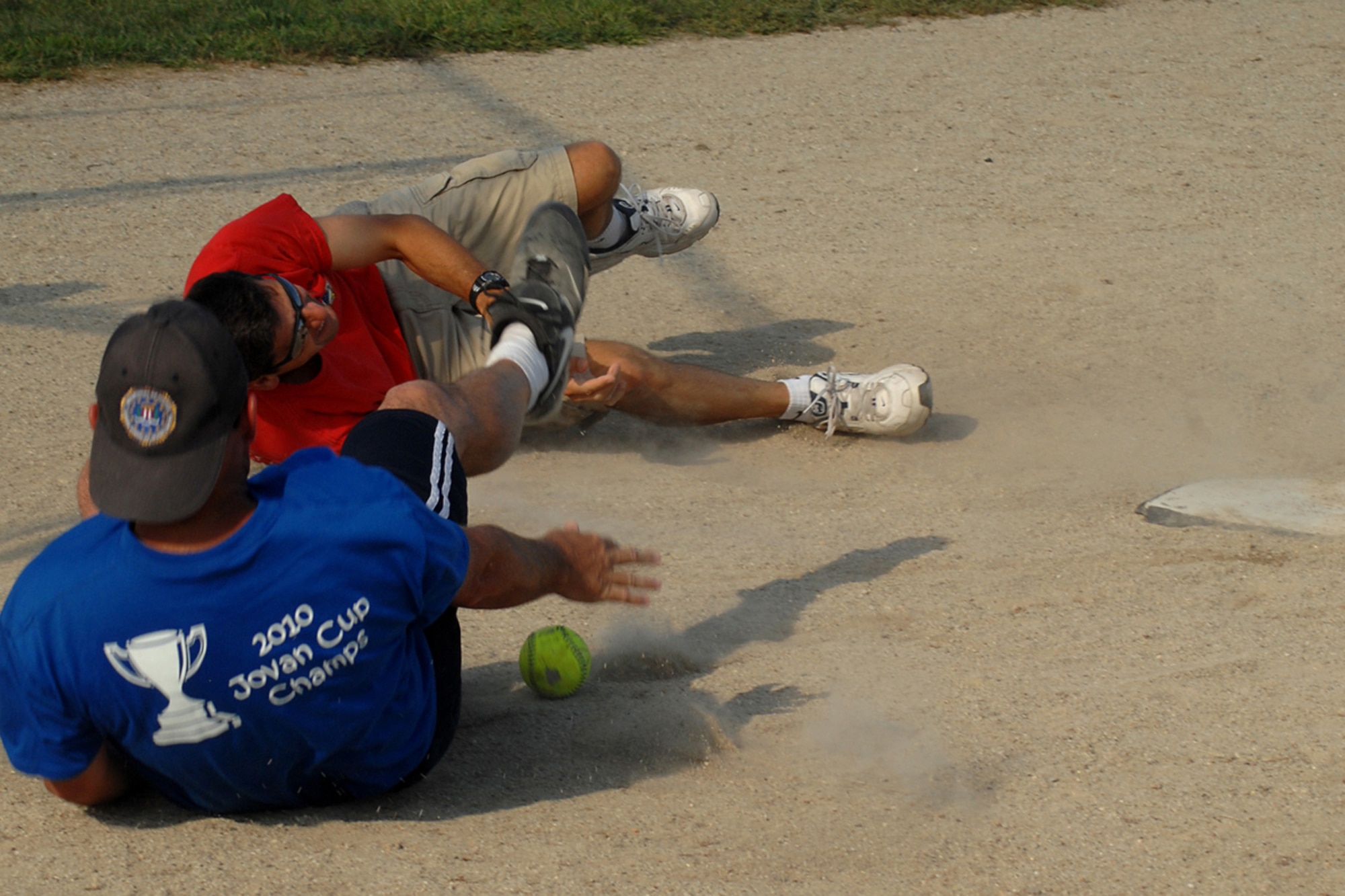 GRISSOM AIR RESERVE BASE, Ind.-- Scott Ward gets pummeled and drops the ball as Dave Schmidt  drives to home base during the 5th Annual Jovanovich Cup Aug. 13. Every year the Fightin' Red Tags and the Dark Side battle it out for the trophy and bragging rights. This year the Red Tags edged the Dark Siders, 13-12. The event is held in memory of Lt. Col. George Jovanovich who died in a car accident in March 2006. (U.S. Air Force photo/Senior Airman Jami K. Lancette)