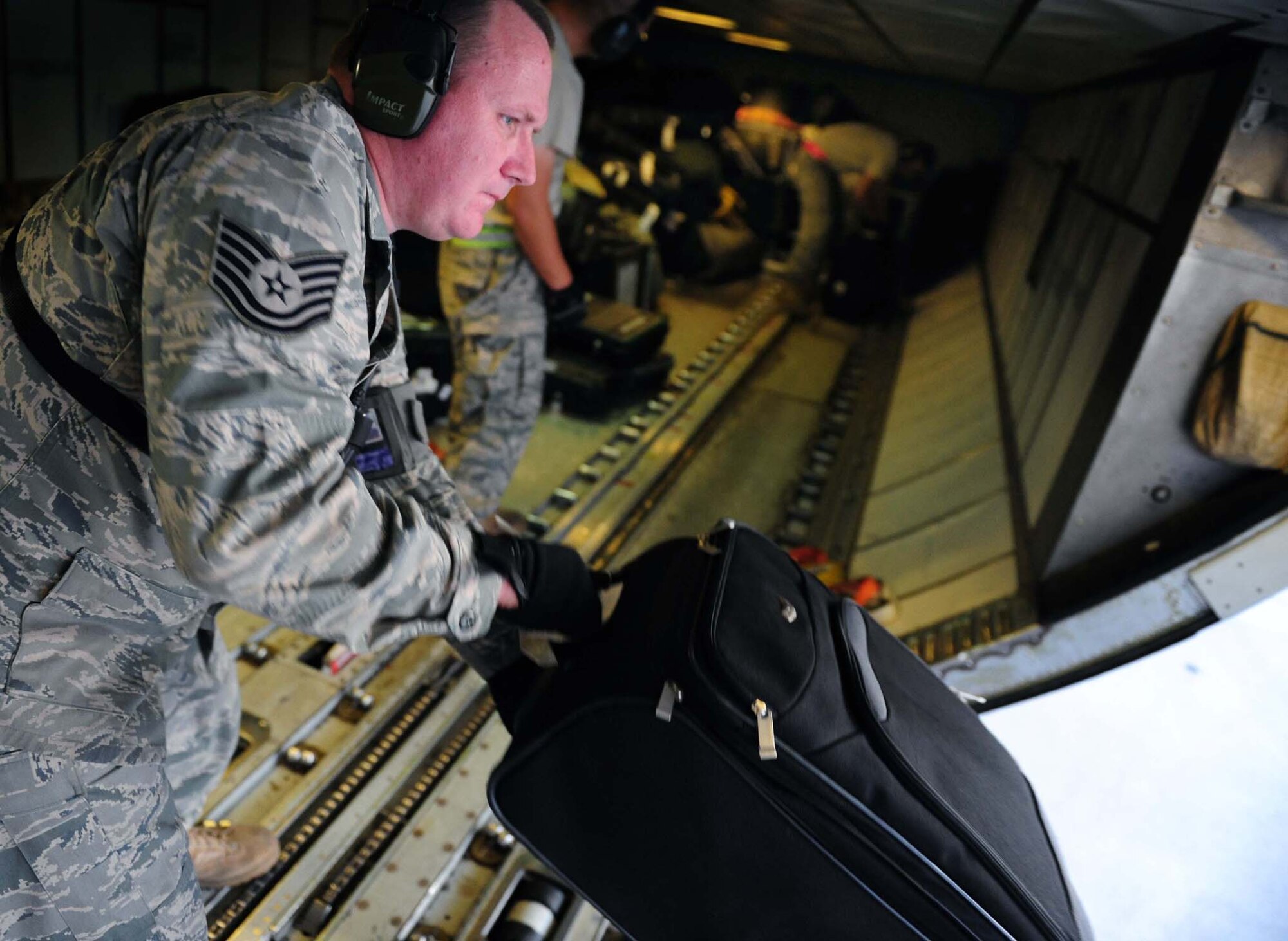 Air Force Tech. Sgt. John Garrelts, 728th Air Mobility Squadron ramp supervisor, places luggage on a conveyor belt Sept. 6, 2011, at Incirlik Air Base, Turkey. Garrelts is currently deployed here from the 86th Aerial Port Squadron, McChord Field, Wash., and volunteered to extend his tour at Incirlik another six months. (U.S. Air Force photo by Senior Airman Anthony Sanchelli)
