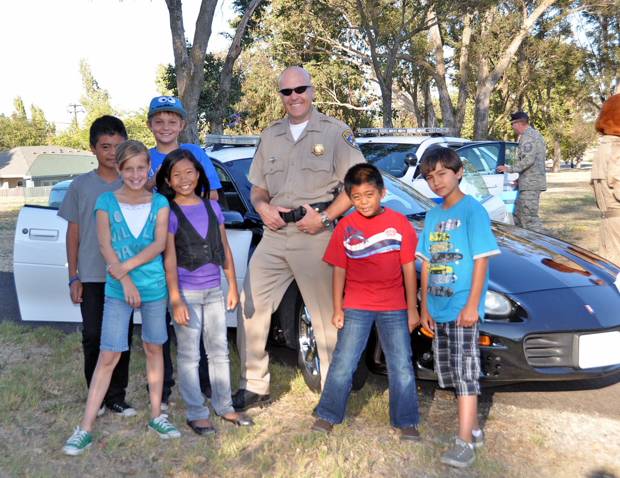 Officer Chris Parker, California Highway Patrol public information officer covering the Solano area, lets the kids take a look inside the front and back of his patrol vehicle Aug. 31 at the National Night Out event. (U.S. Air Force photo/ Airman Madelyn Ottem)