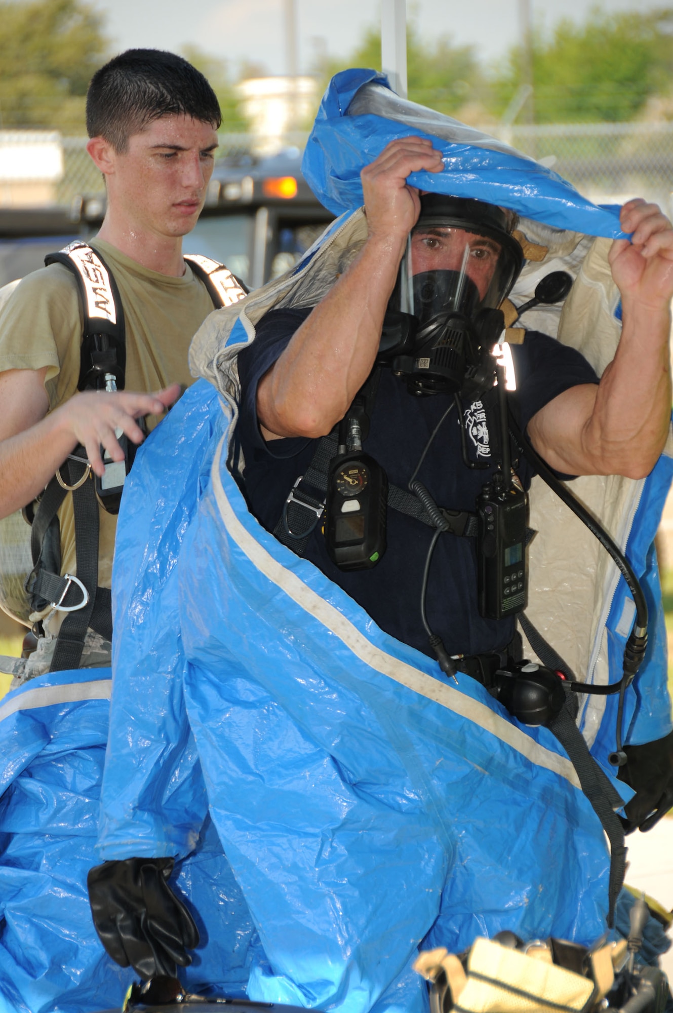Firefighters Aric Schneeberger, left, and Rusty Bell suit up in protective gear enter Matero Hall during a bioterrorism exercise Aug. 31.  In the scenario, a package was delivered containing a suspicious white power substance was delivered.   Two "victims" required medical treatment and 60 occupants of the building  were evacuated and underwent decontamination as a precaution.  (U.S. Air Force photo by Kemberly Groue)